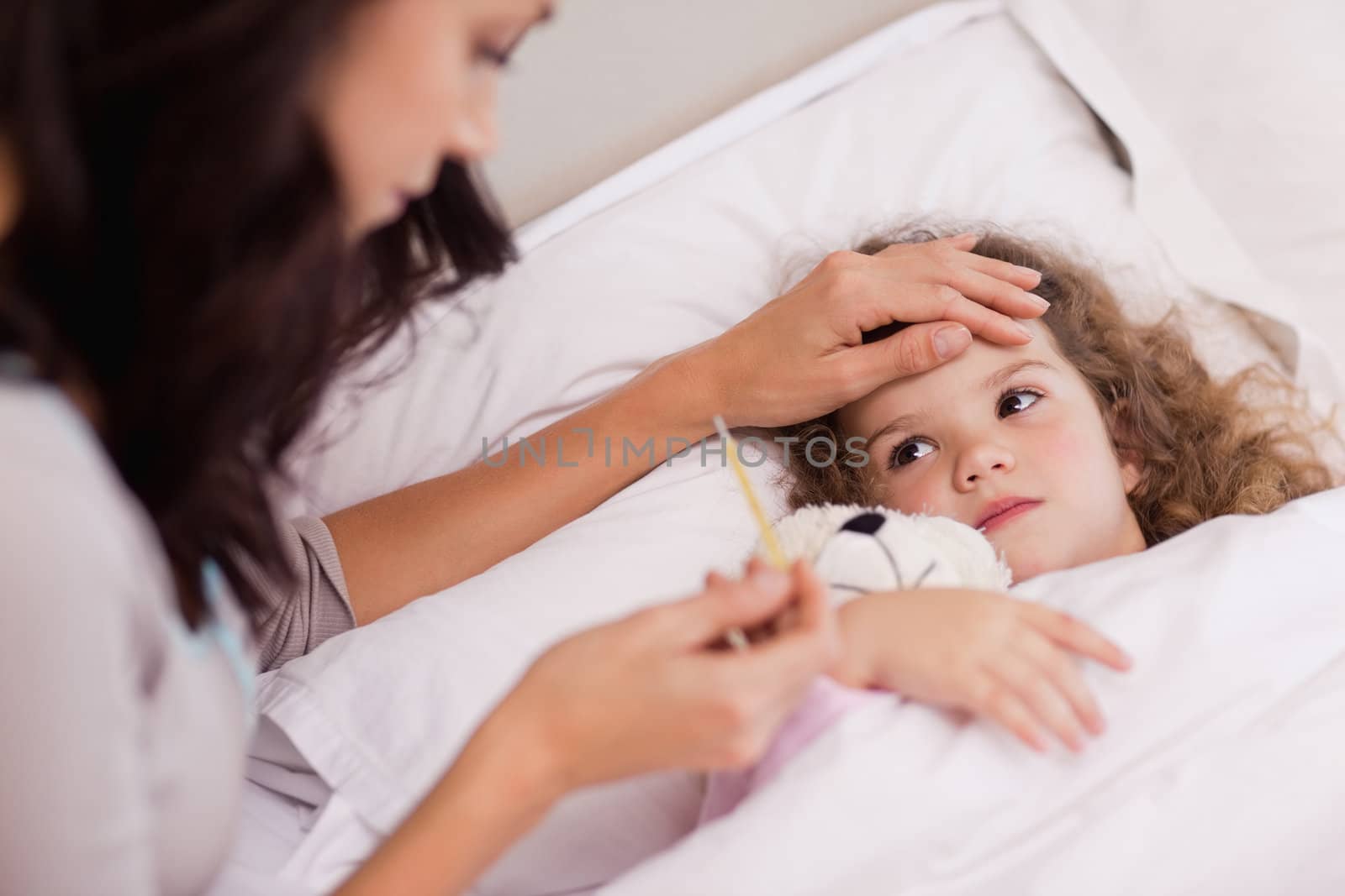 Young mother taking care of her sick daughter