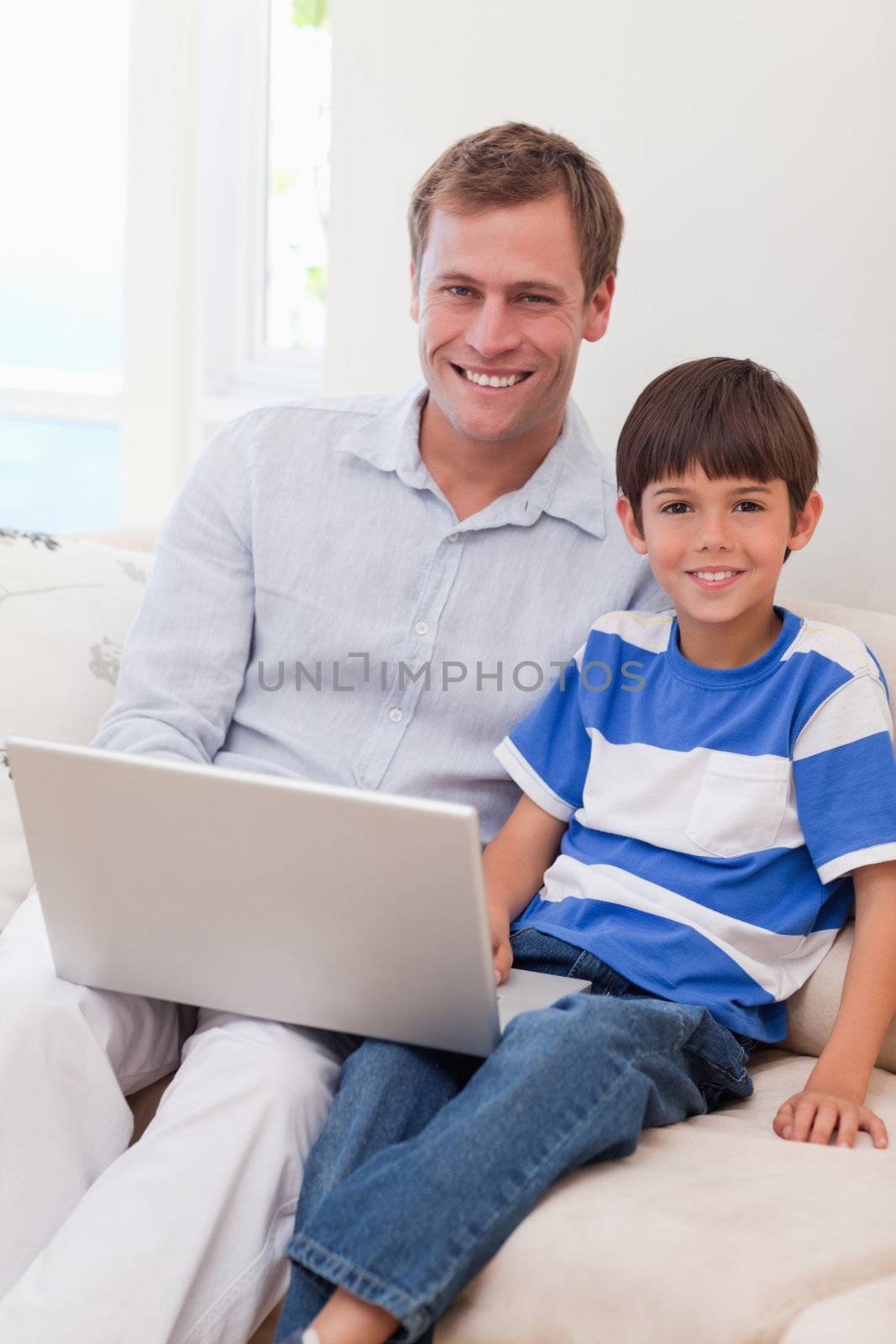 Smiling young father and son surfing the internet together