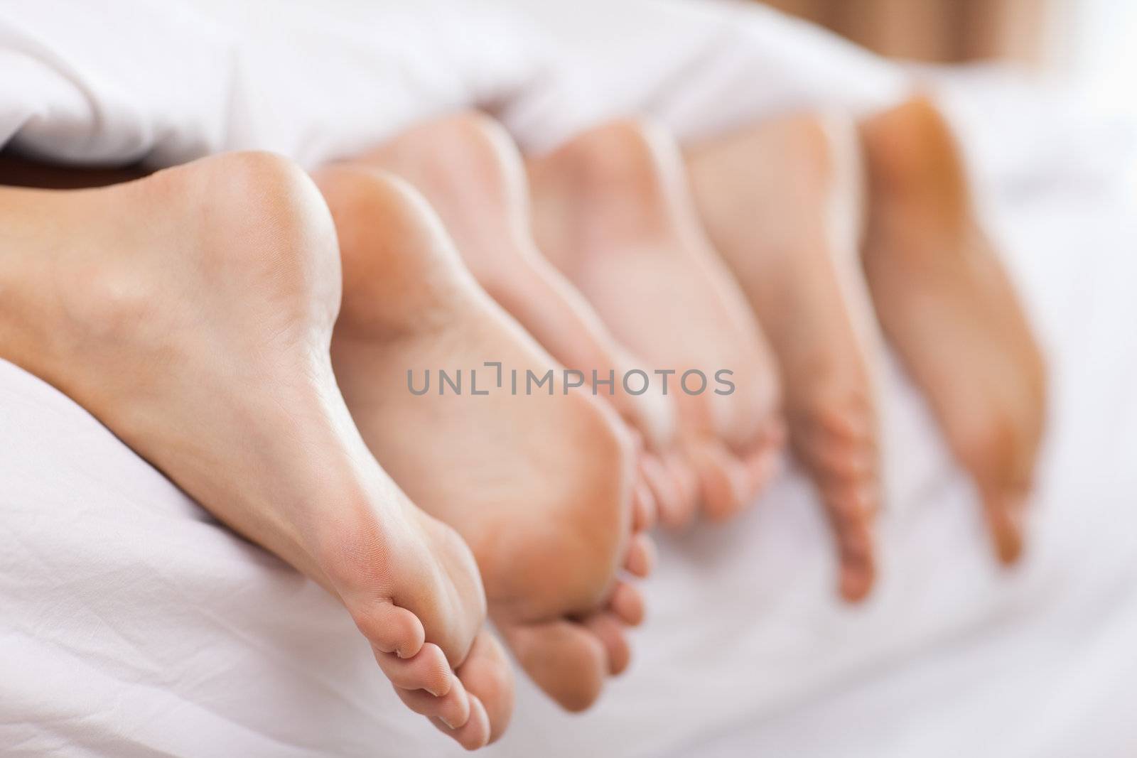 Close up of six feet in a bed