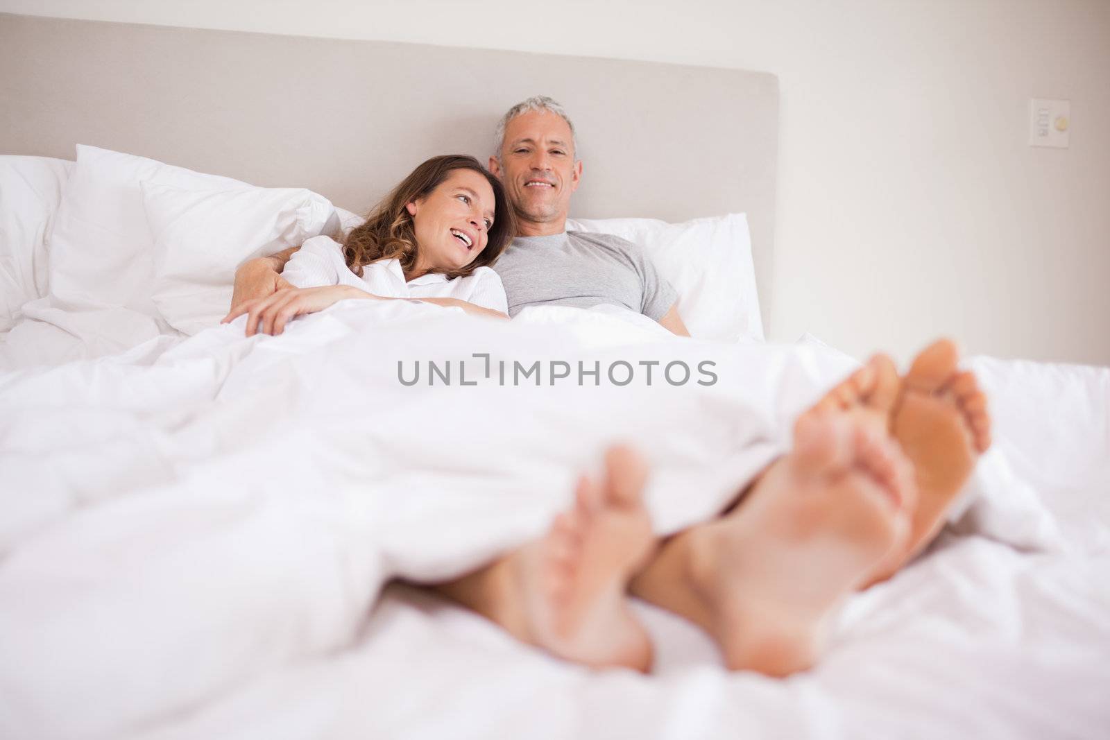 Charming couple lying in a bed while hugging