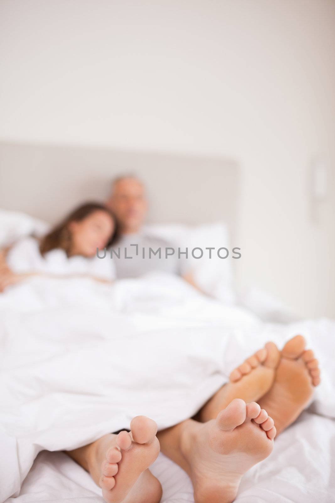 Portrait of a couple sleeping with the camera focus on their feet