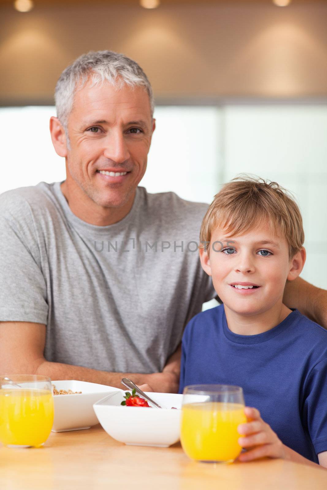 Portrait of a boy and his father having breakfast in a kitchen