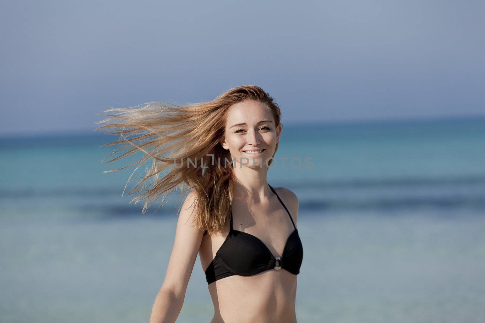 Young woman with black bikini girls laughing at the beach with blue sky in summer vacation