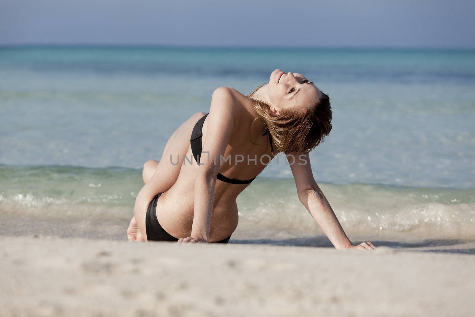 Young woman with black bikini Sexy girls on the beach in water with blue sky in summer vacation