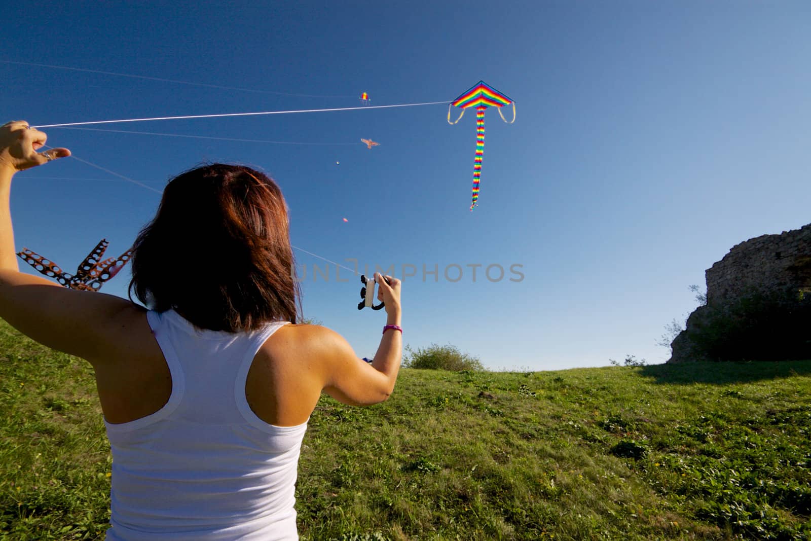 Young girl playing with colorful flying kite on sunny autumn day