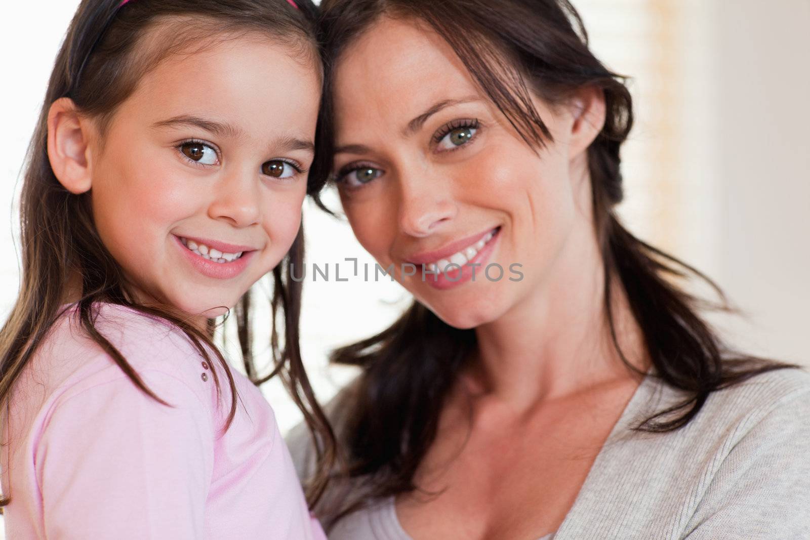 Close up of a girl and her mother smiling at the camera