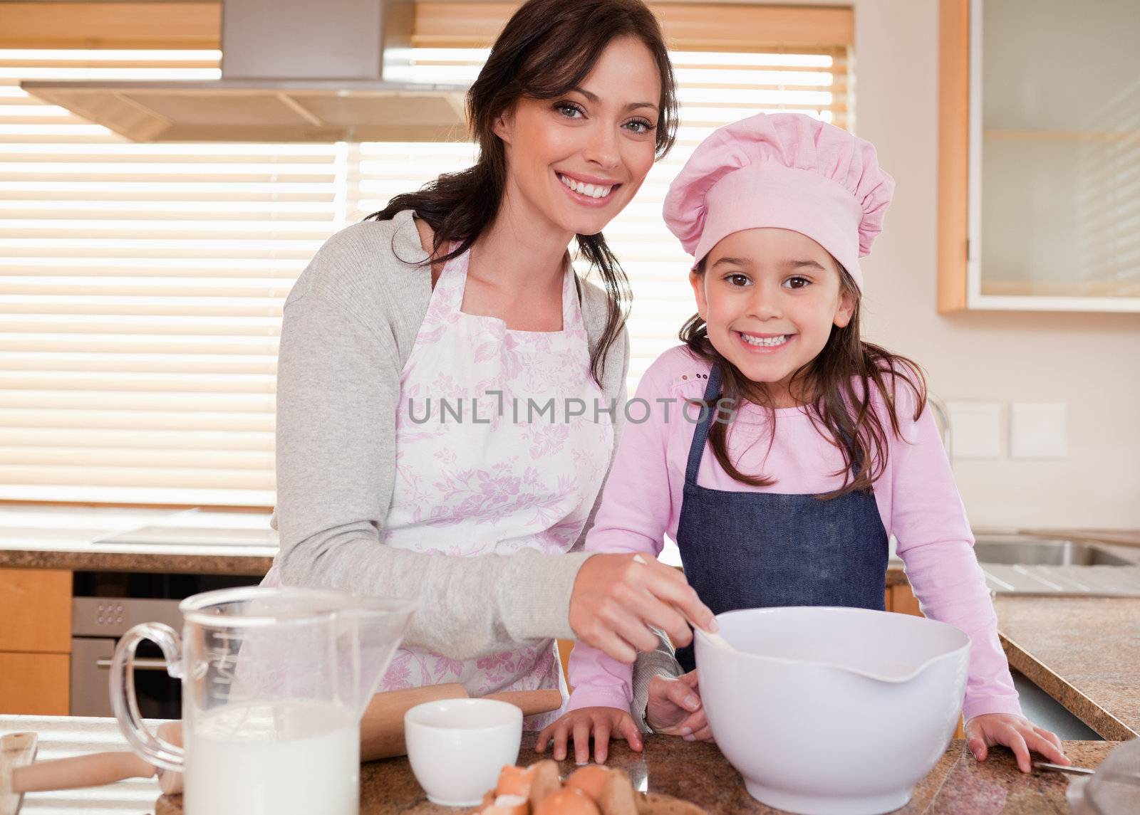 Mother baking with her daughter in a kitchen