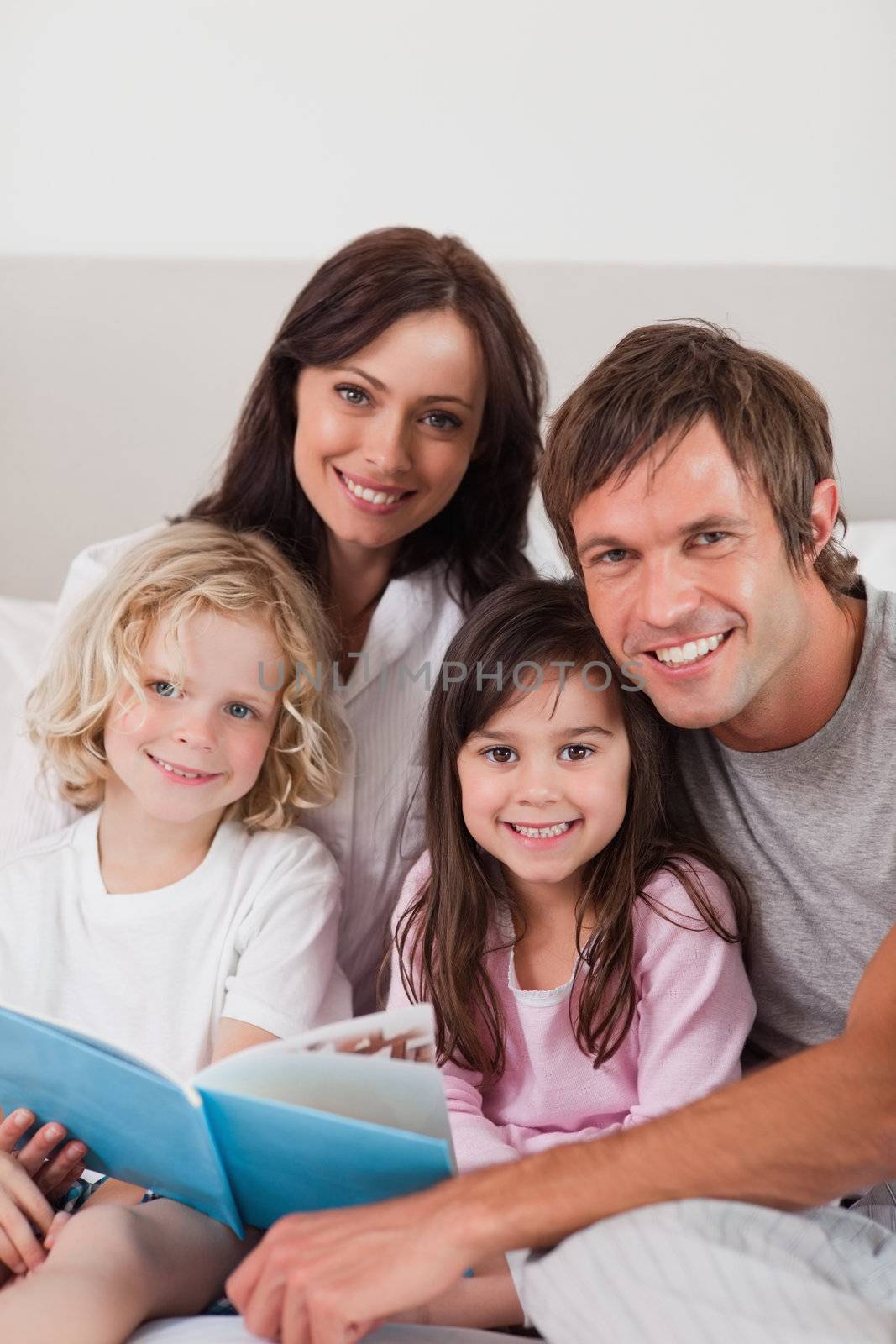 Portrait of a happy family reading a book by Wavebreakmedia