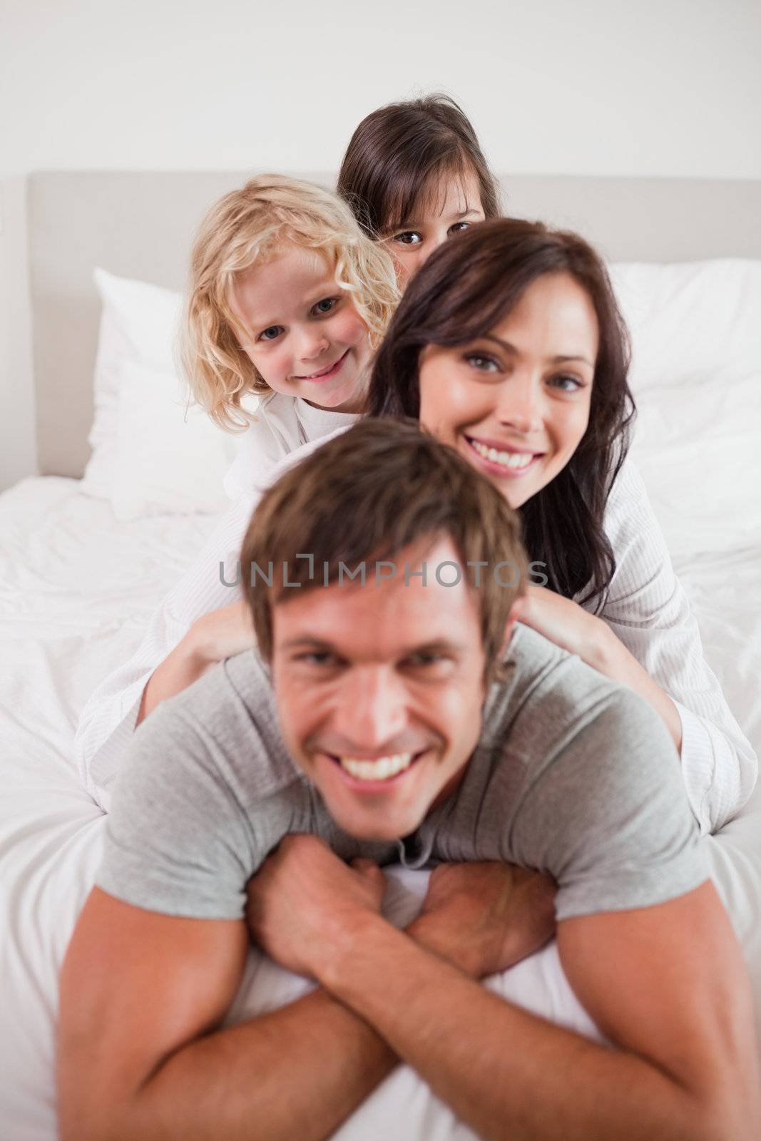 Portrait of a family lying on each other by Wavebreakmedia