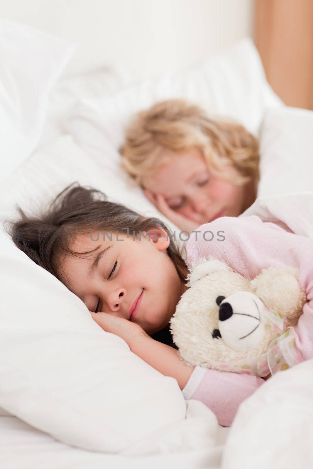 Portrait of siblings sleeping in a bedroom