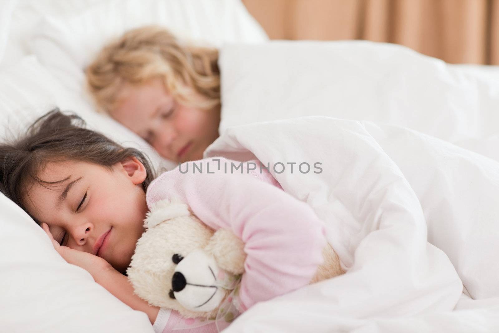 Quiet siblings sleeping in a bedroom