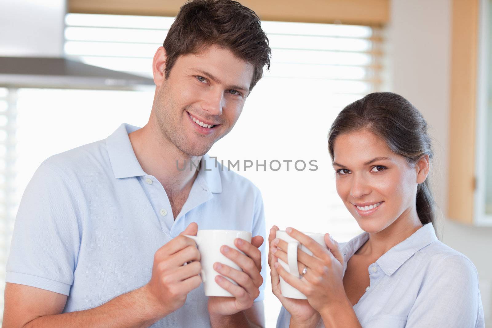 Happy couple drinking coffee in their kitchen