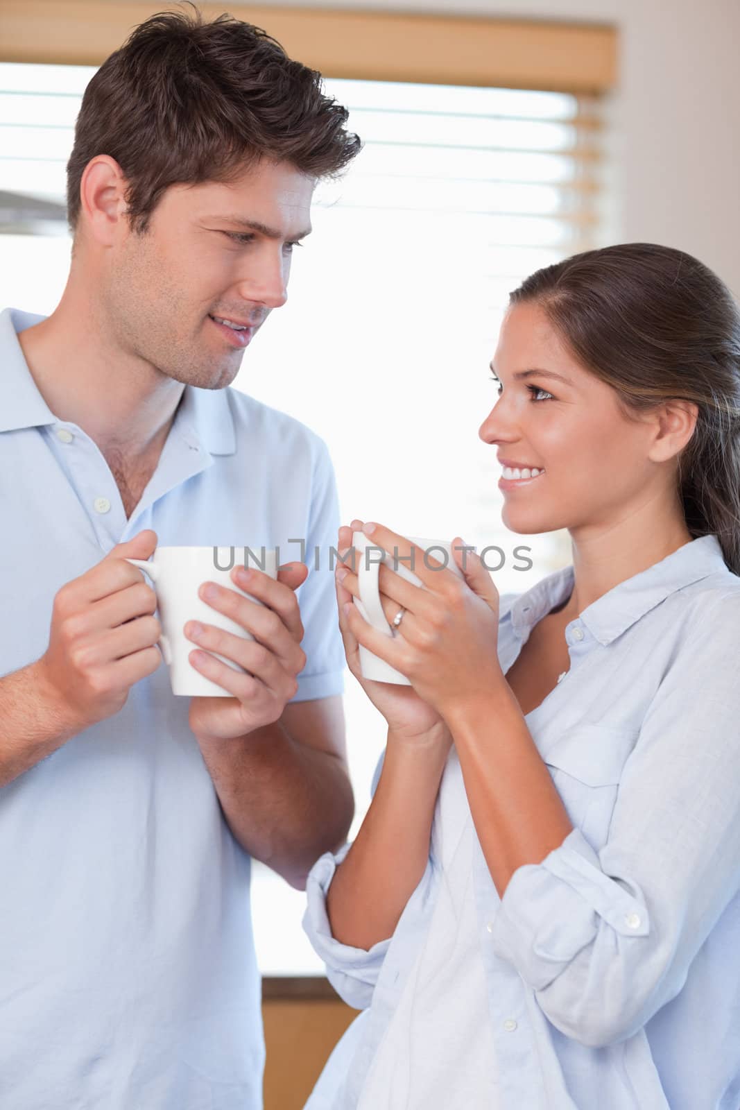 Portrait of a happy couple drinking coffee in their kitchen