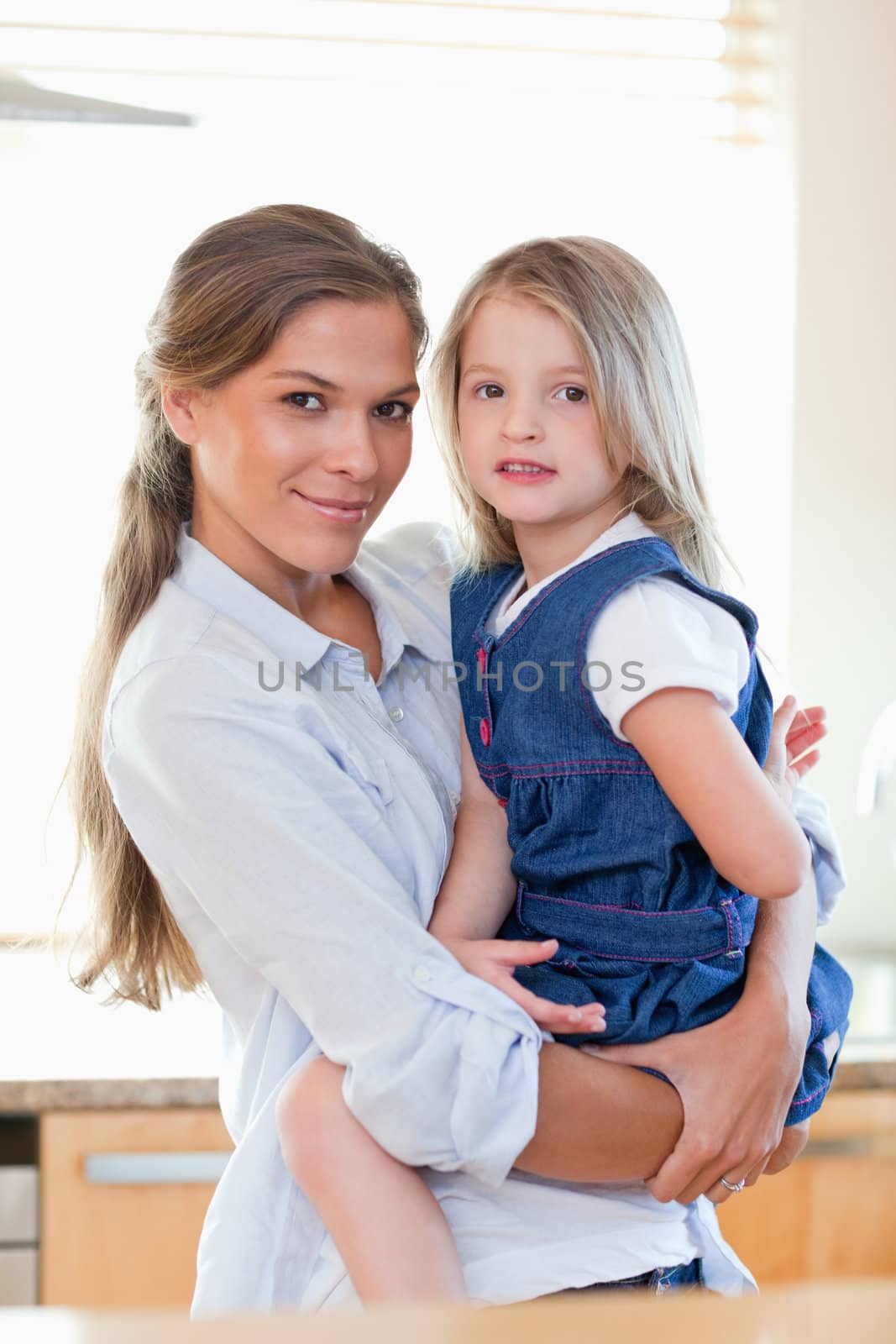 Portrait of a mother and her daughter posing in their kitchen
