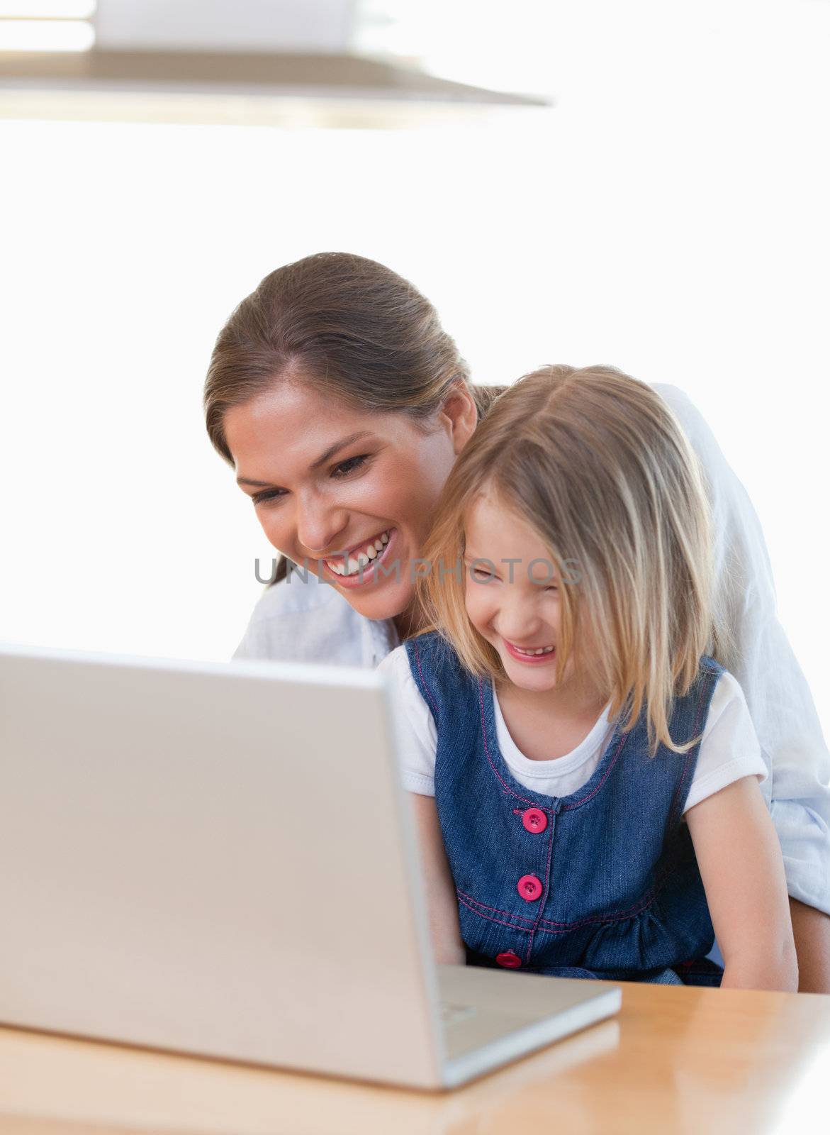 Portrait of a mother and her daughter using a notebook in their kitchen