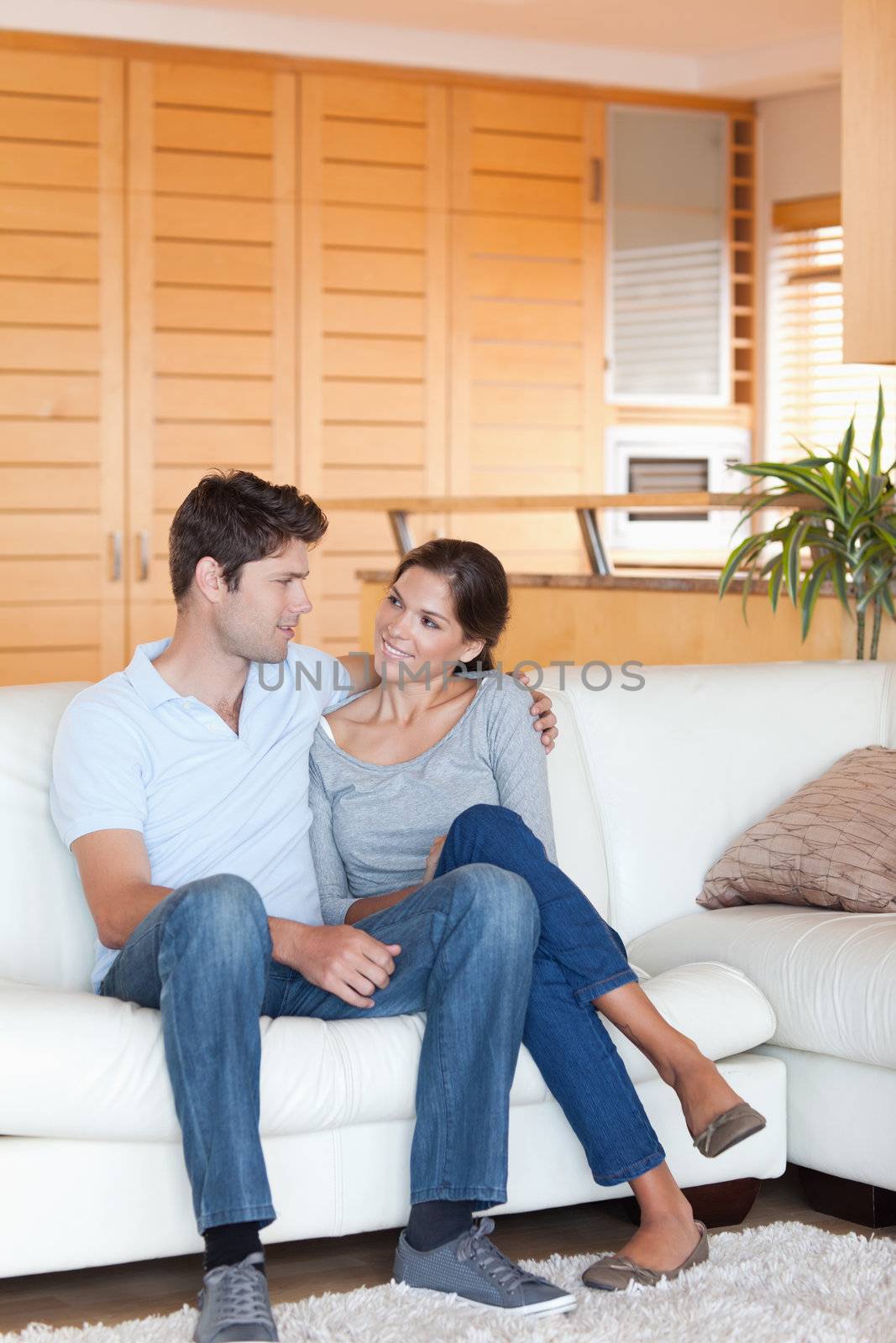 Portrait of a couple sitting on a sofa while looking at each other