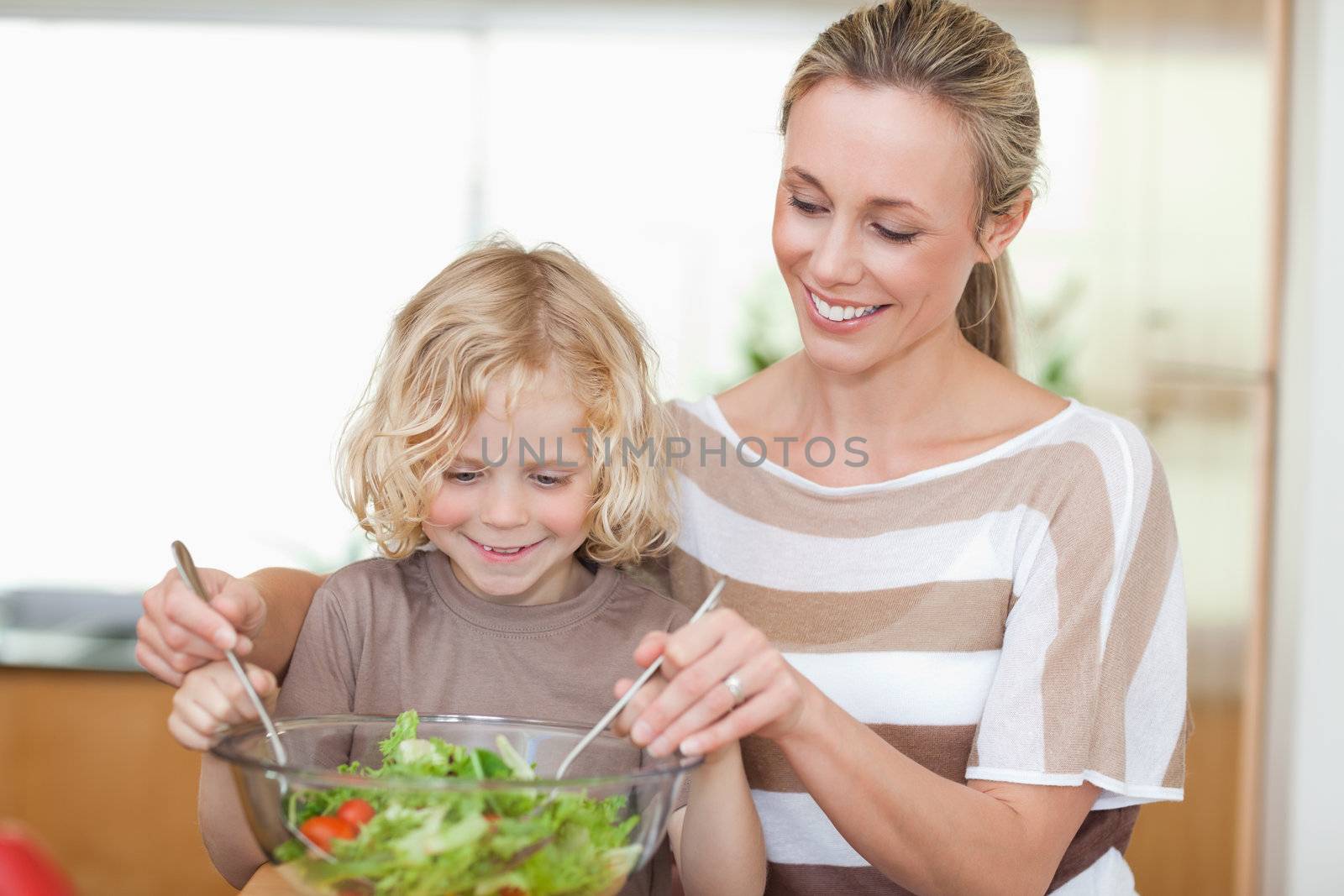 Mother and son preparing salad together