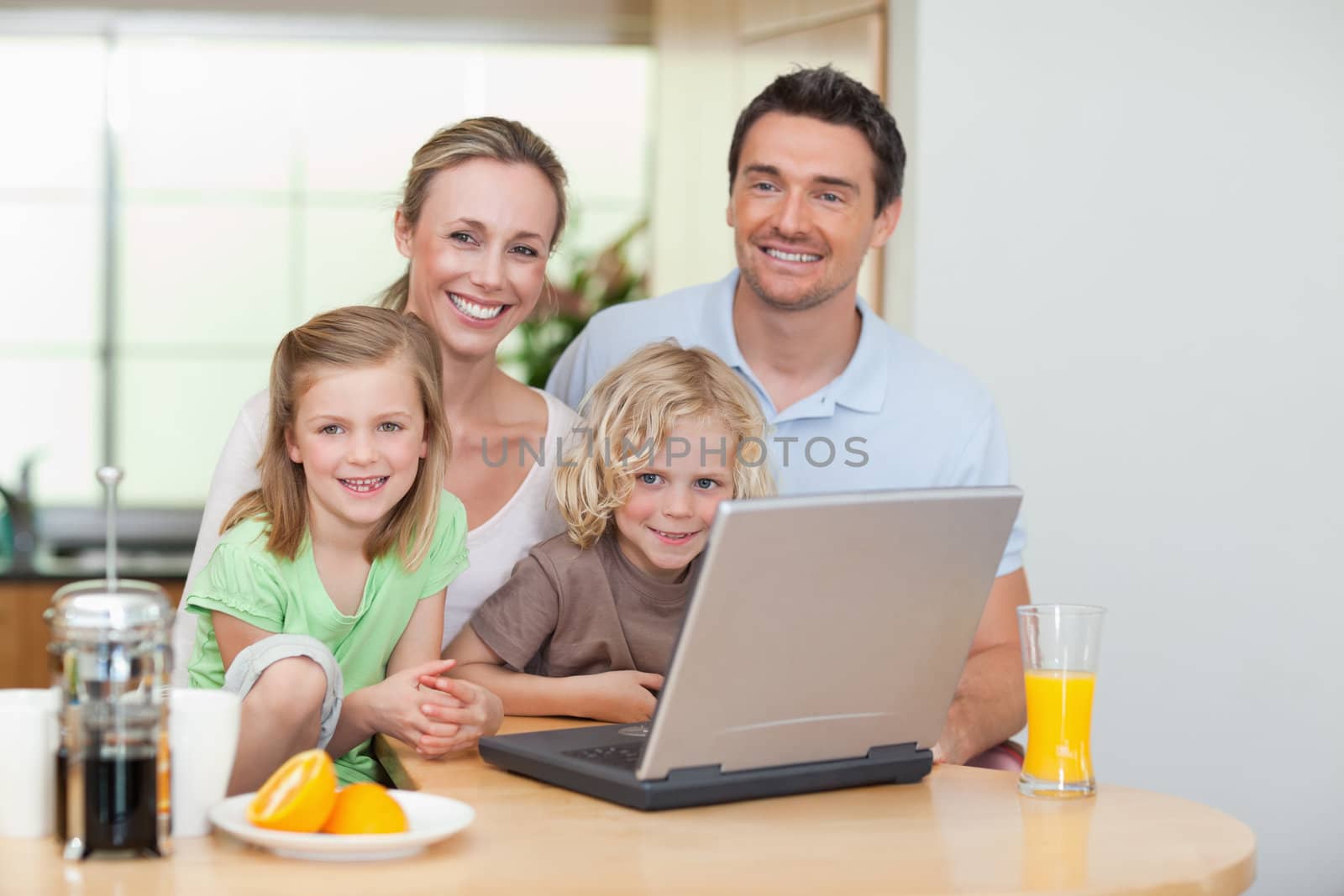Smiling family using the internet in the kitchen by Wavebreakmedia