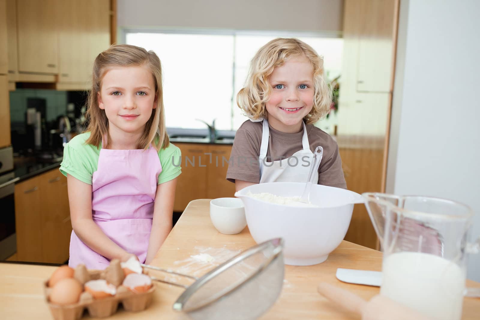 Smiling siblings preparing dough together