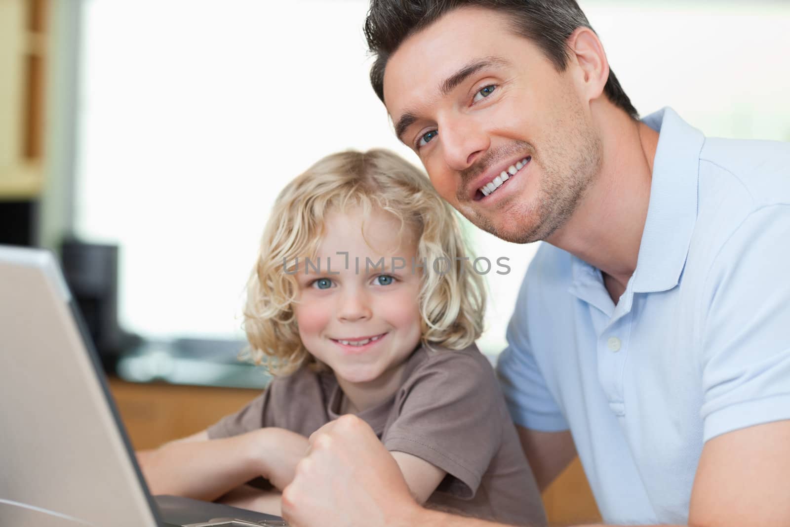 Smiling father and son together with notebook