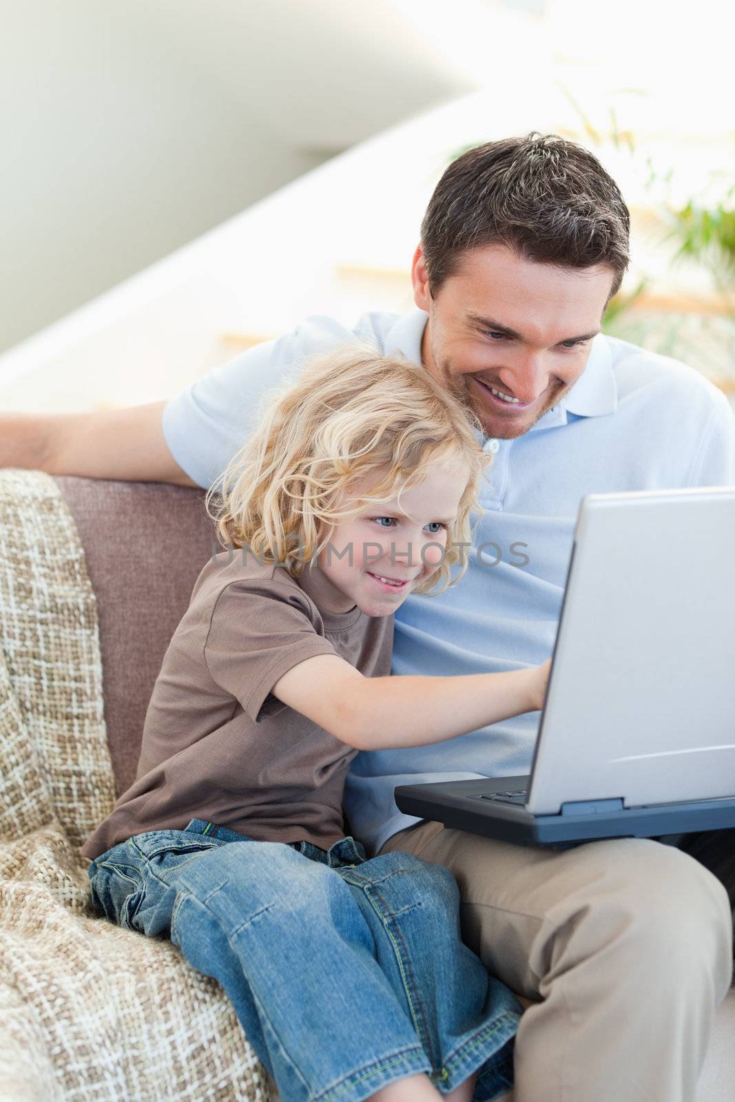 Father and son together with notebook on sofa
