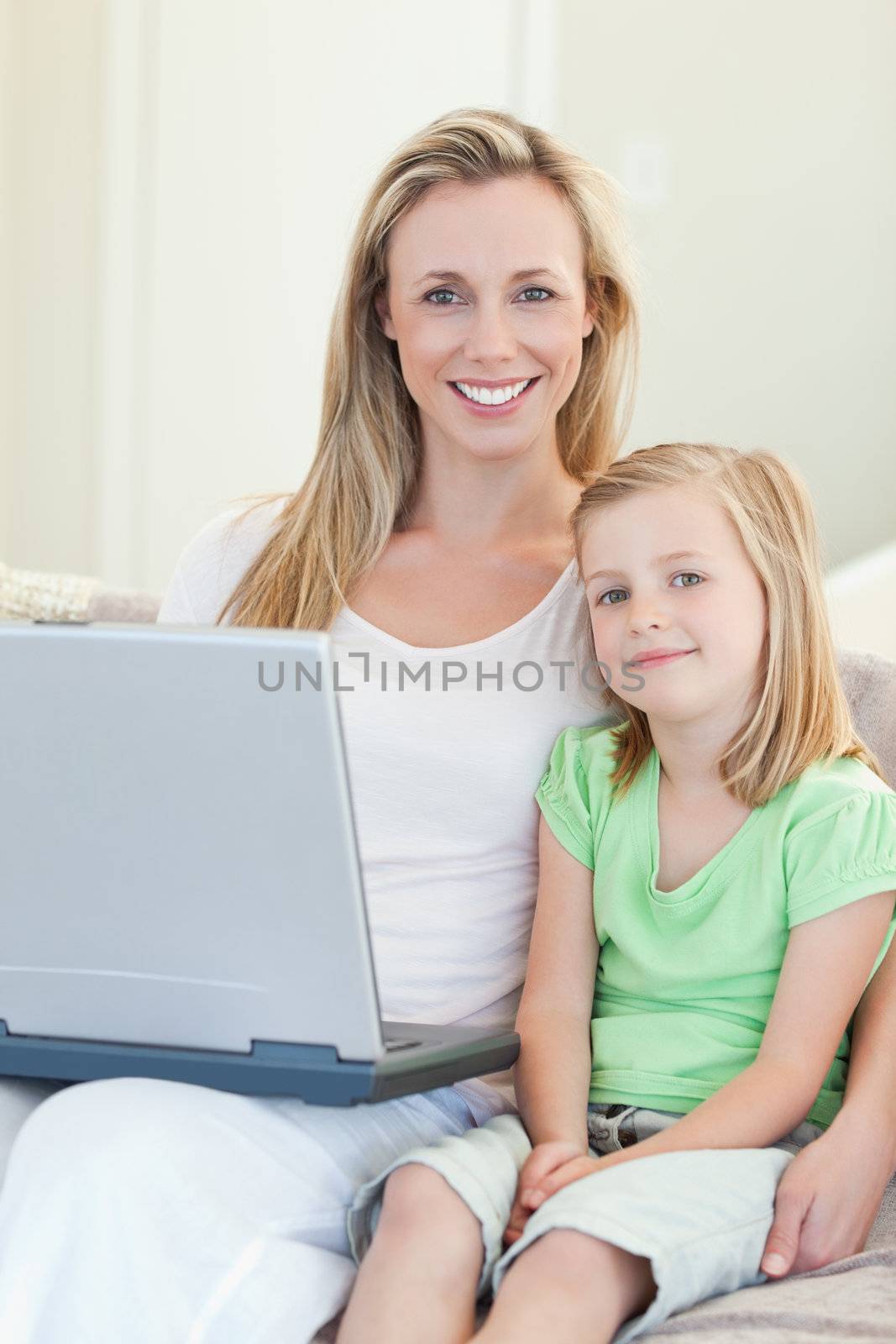 Mother and daughter together with laptop on sofa