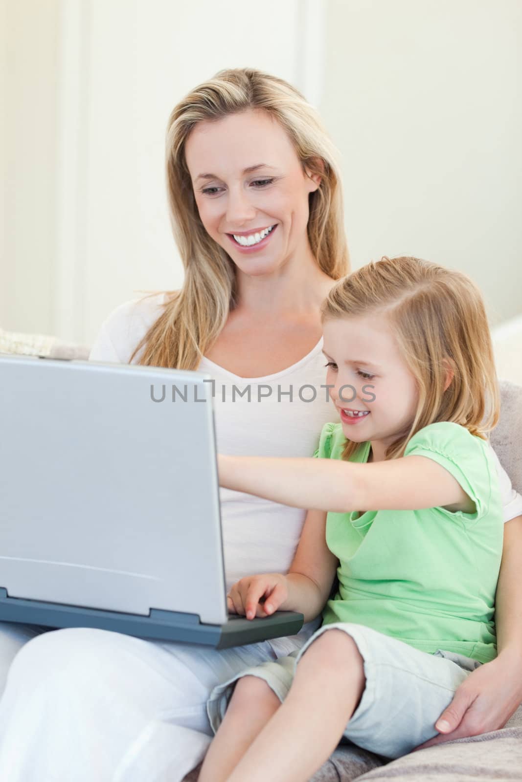 Mother and daughter together with laptop on couch