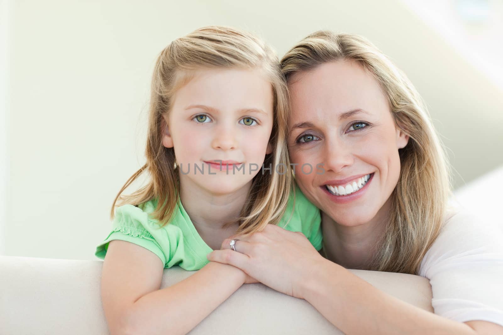 Smiling mother and daughter together on the couch