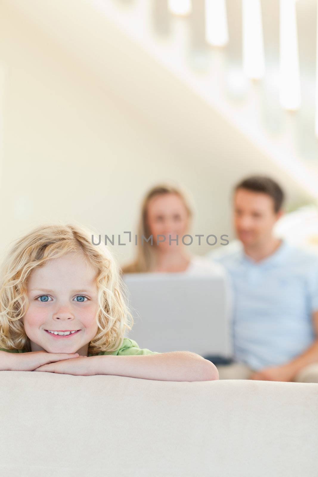 Happy boy with parents in the background by Wavebreakmedia