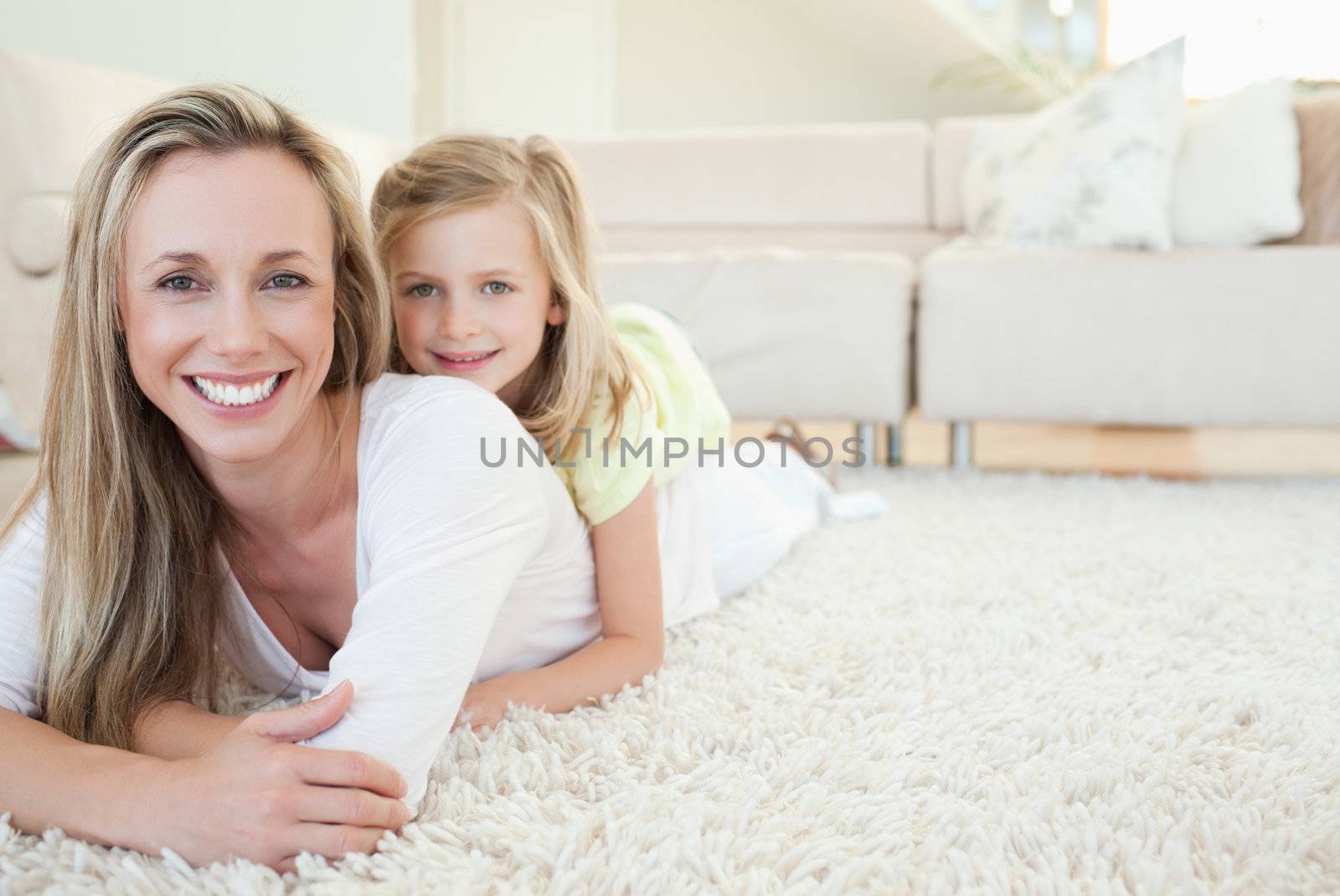 Mother and daughter lying on the floor together