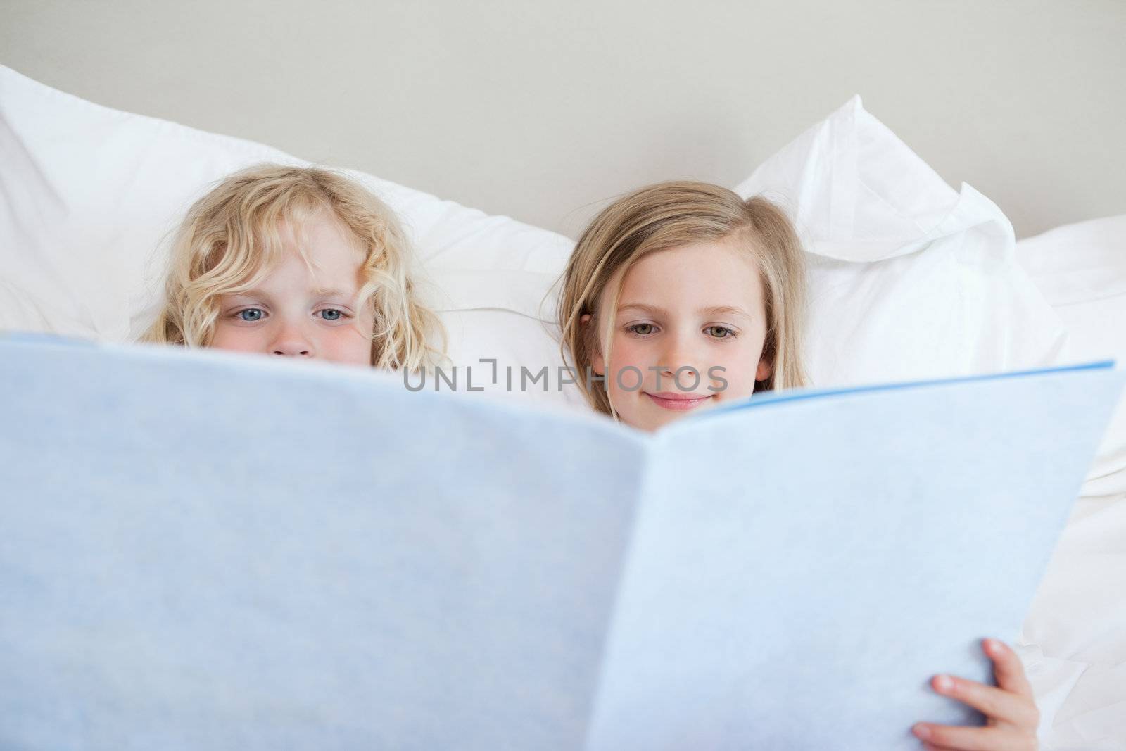 Siblings reading bedtime story together