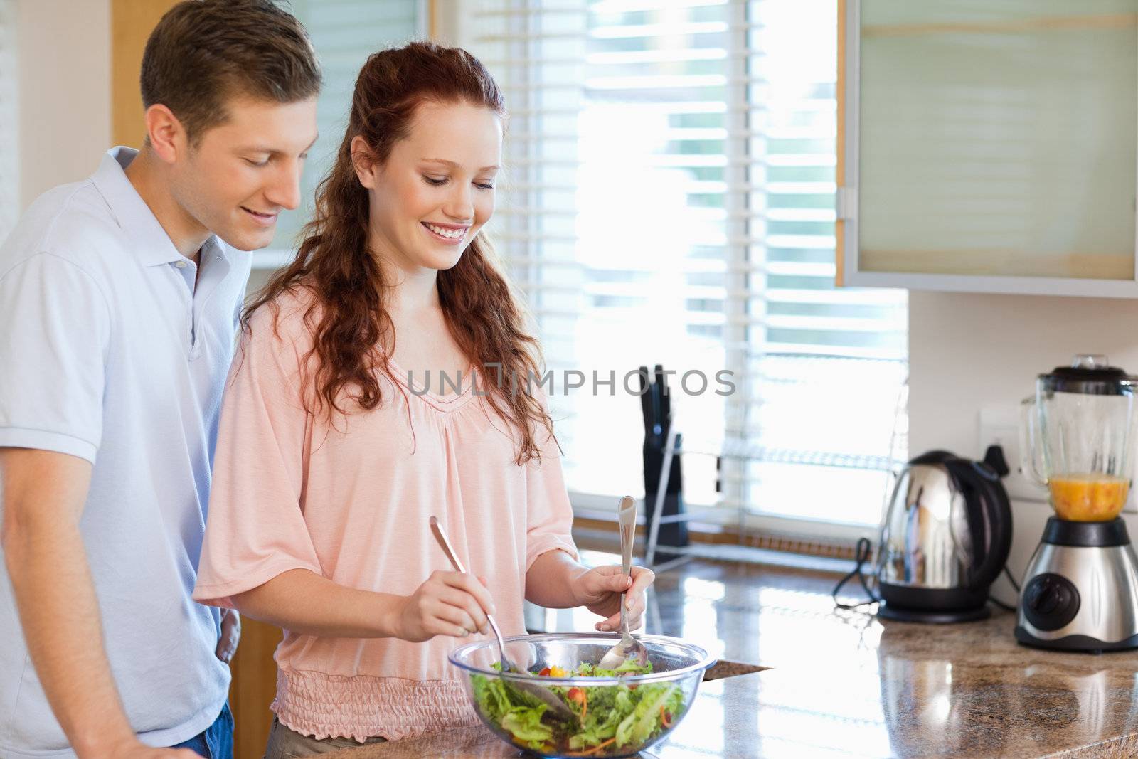 Couple with bowl of healthy salad in the kitchen