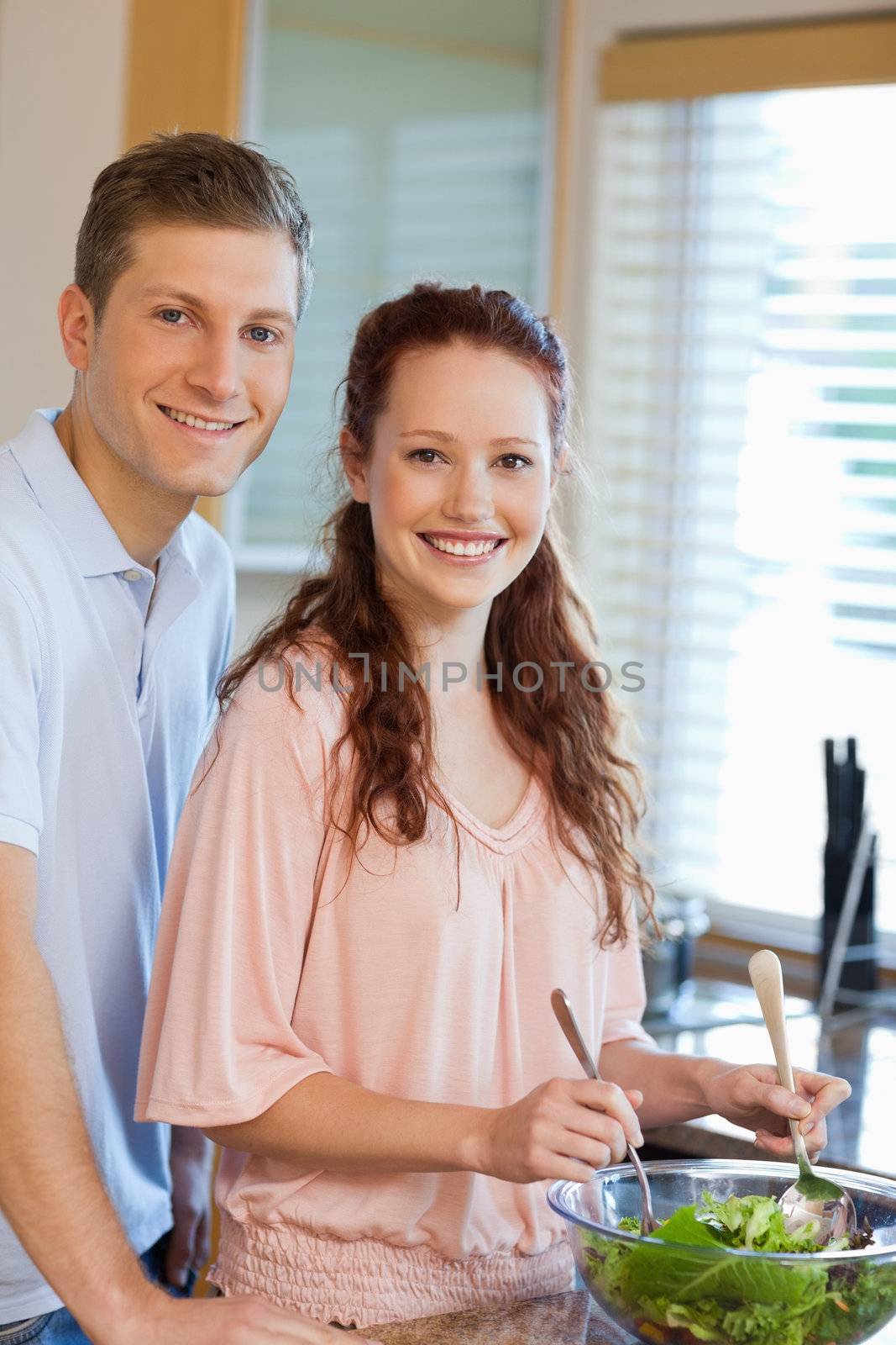 Couple with healthy green salad in the kitchen