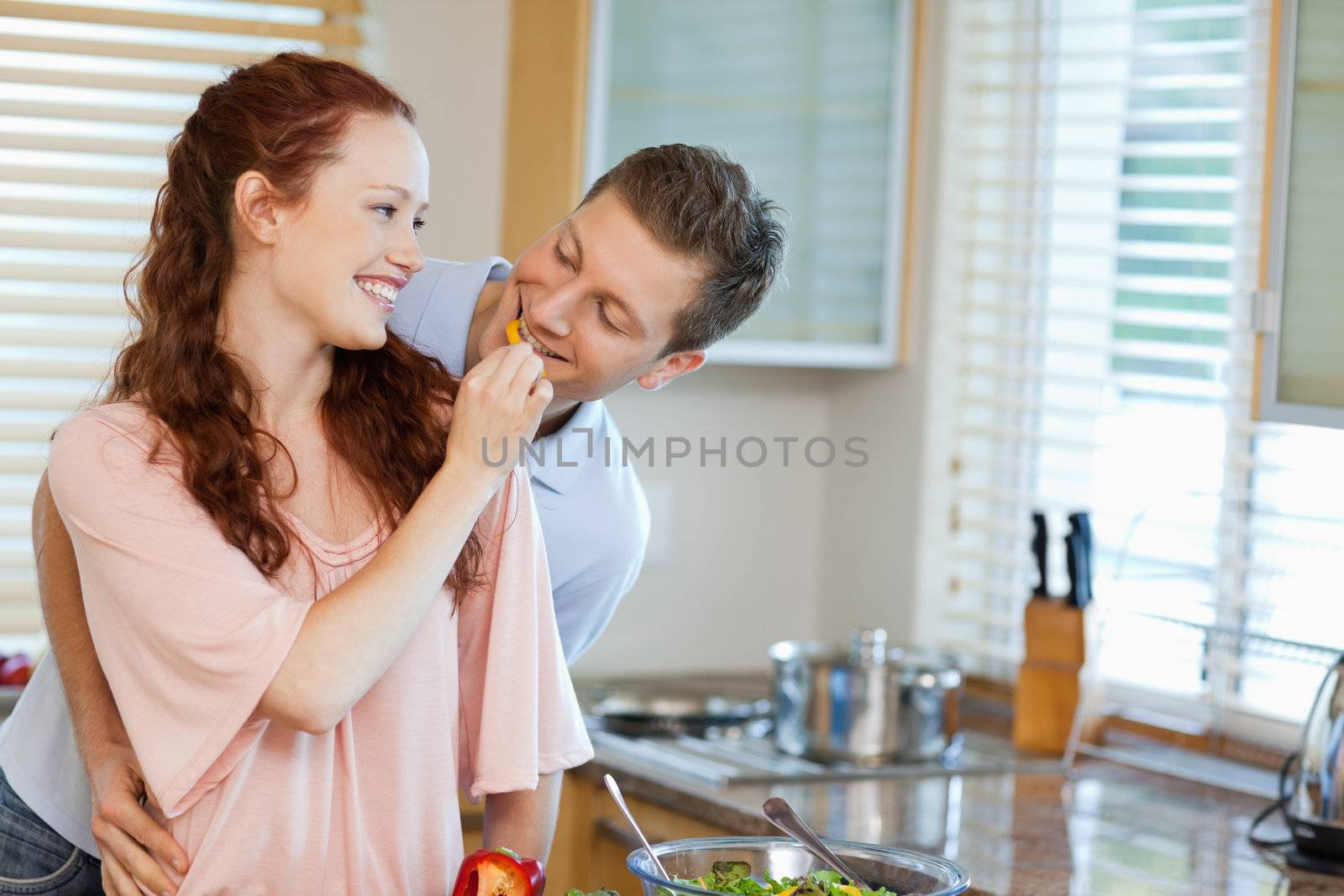 Young woman giving her boyfriend some bell pepper