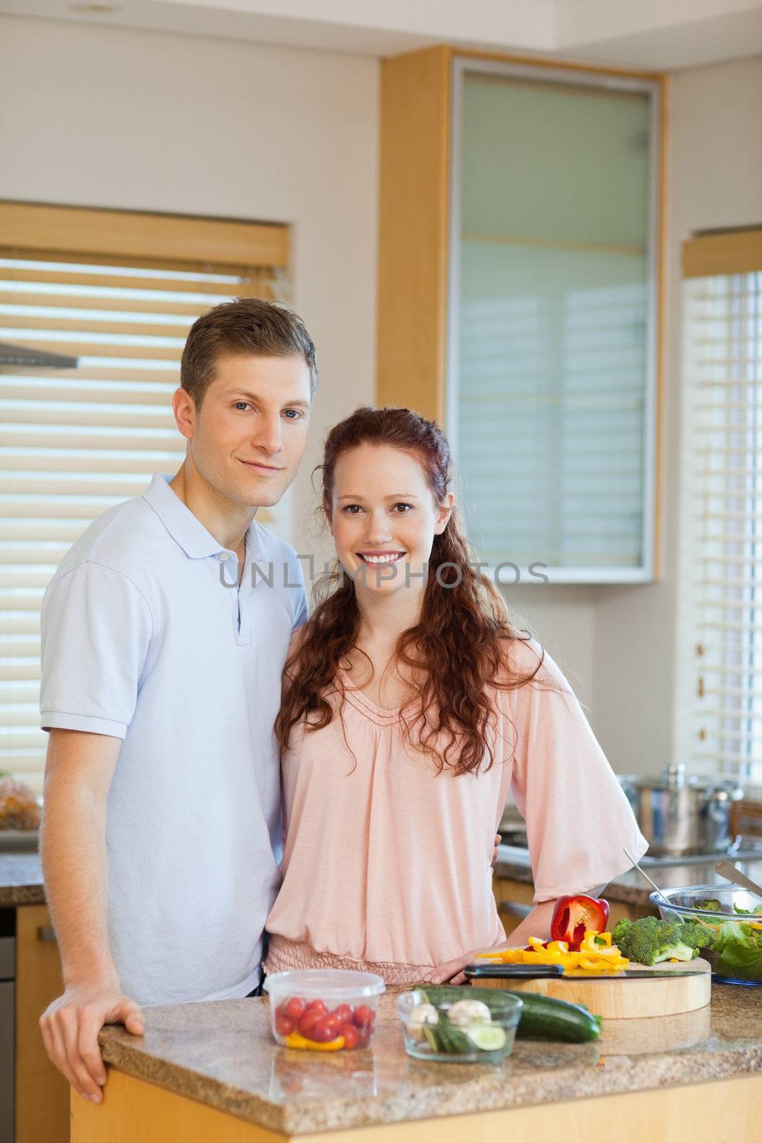 Young couple standing behind kitchen counter together