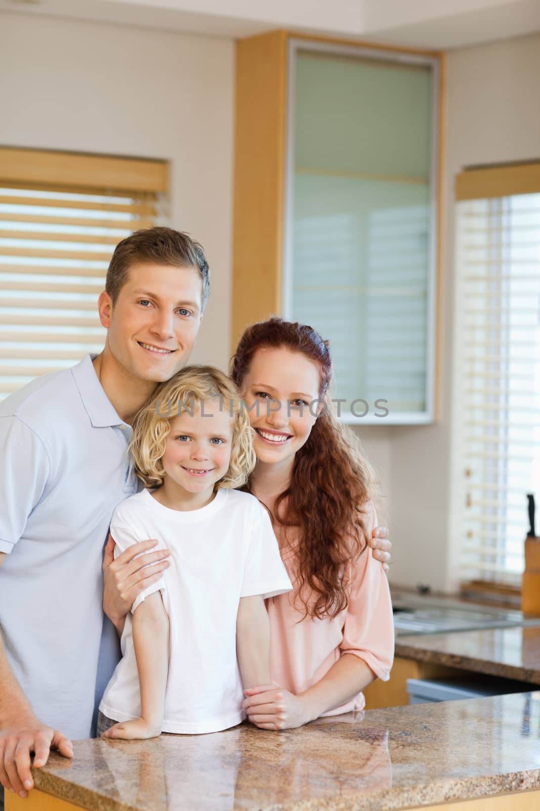 Cheerful family standing behind the kitchen counter together