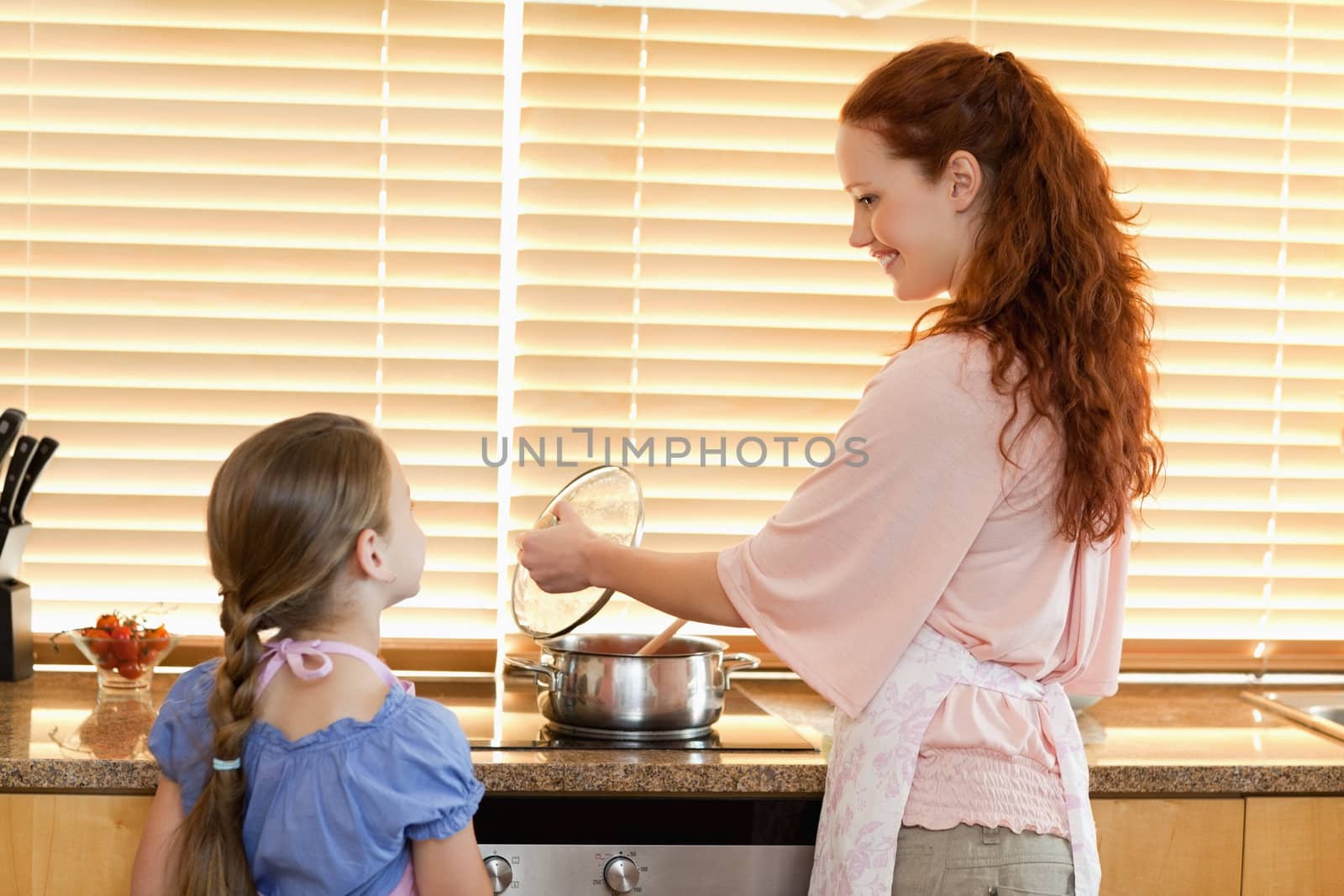 Smiling mother showing her daughter what shes cooking