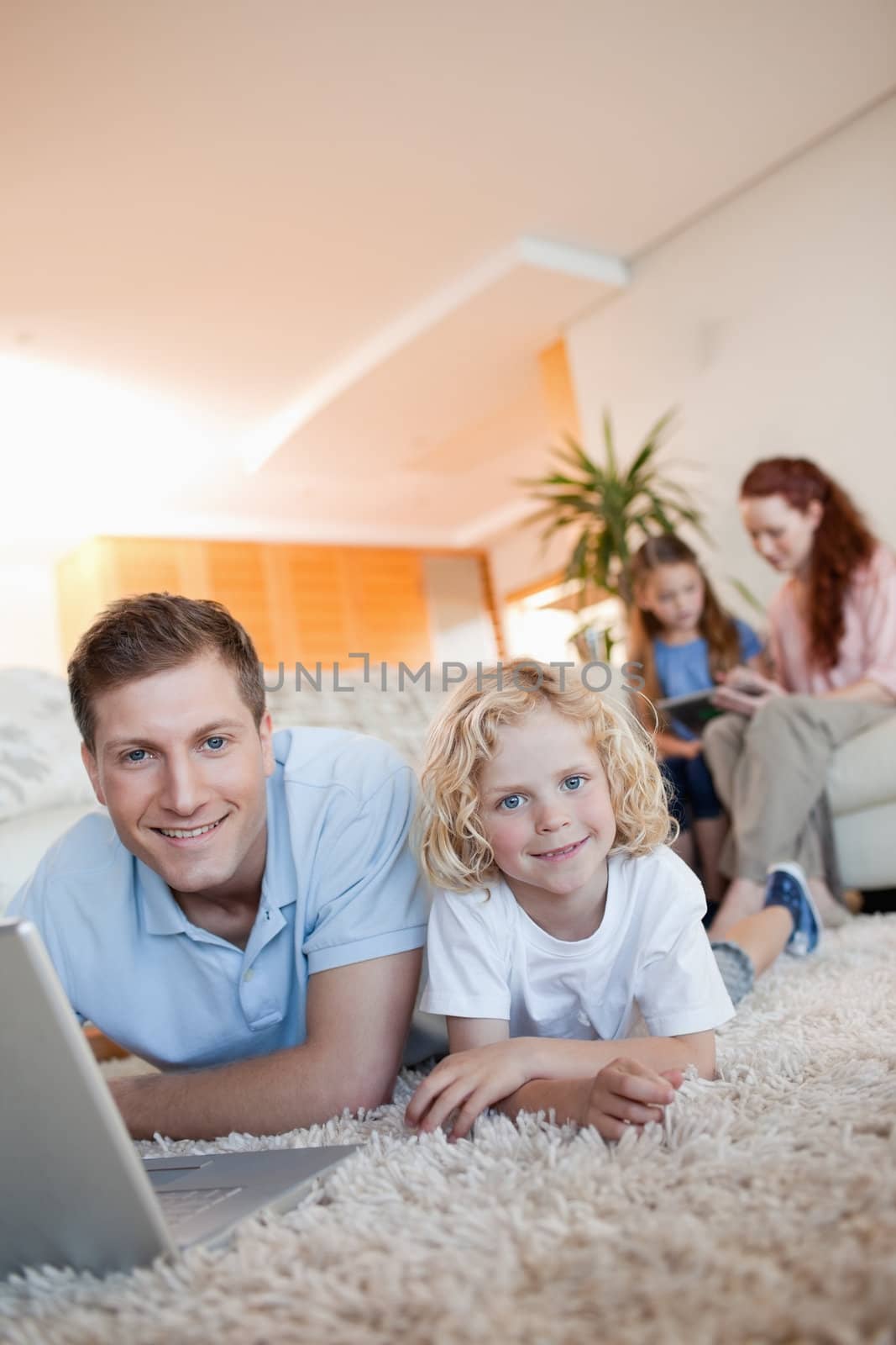 Father and son using internet on the floor by Wavebreakmedia