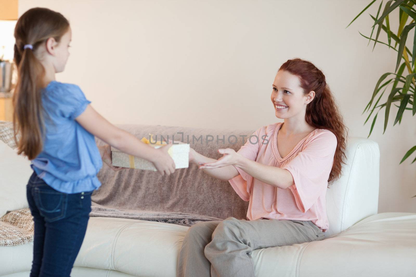 Young daughter giving her mother a gift