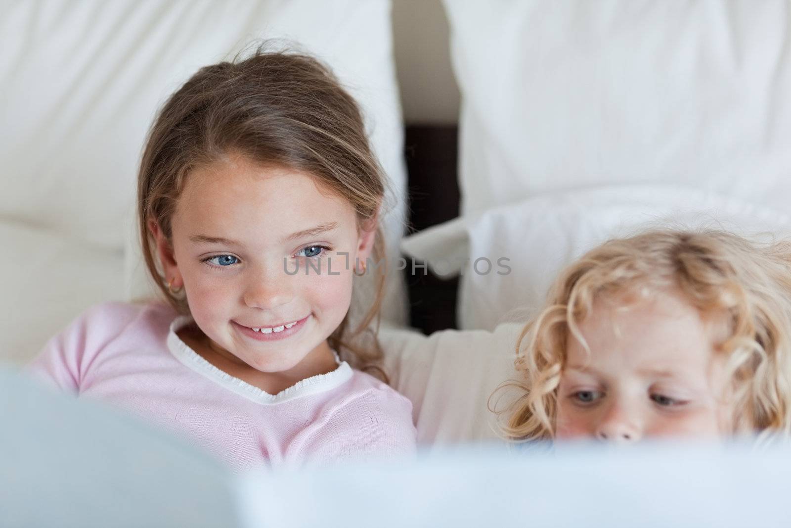 Girl reading a fairy tale for her little brother