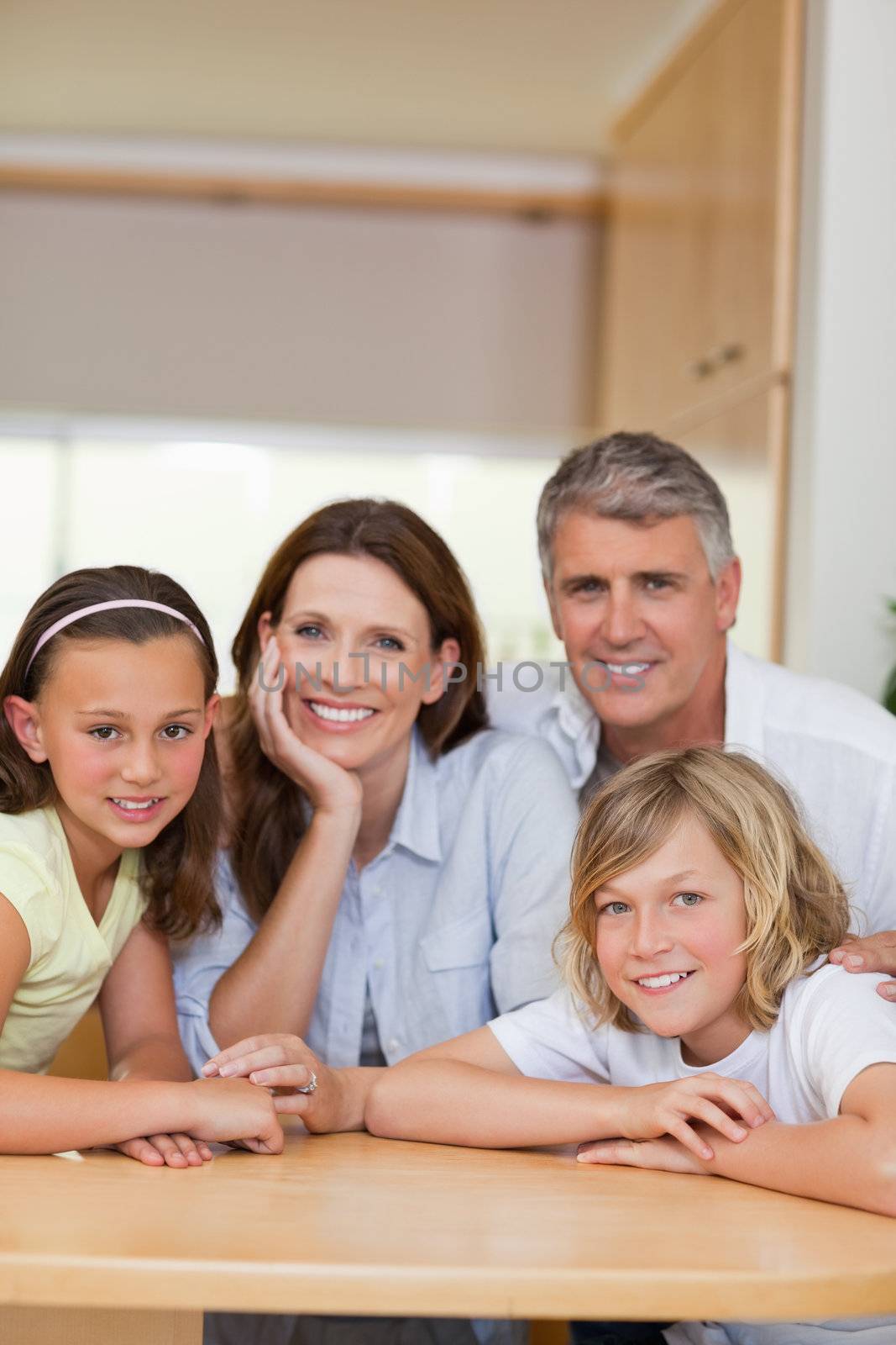 Smiling family behind kitchen table by Wavebreakmedia
