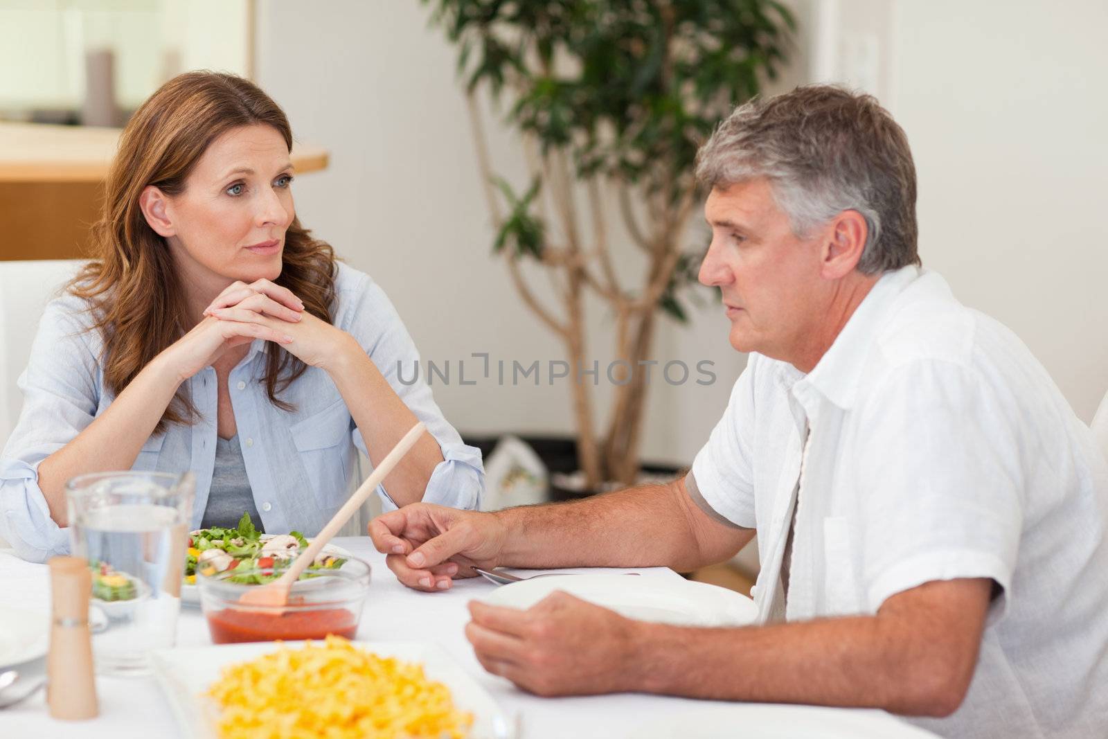 Family sitting at dinner table by Wavebreakmedia