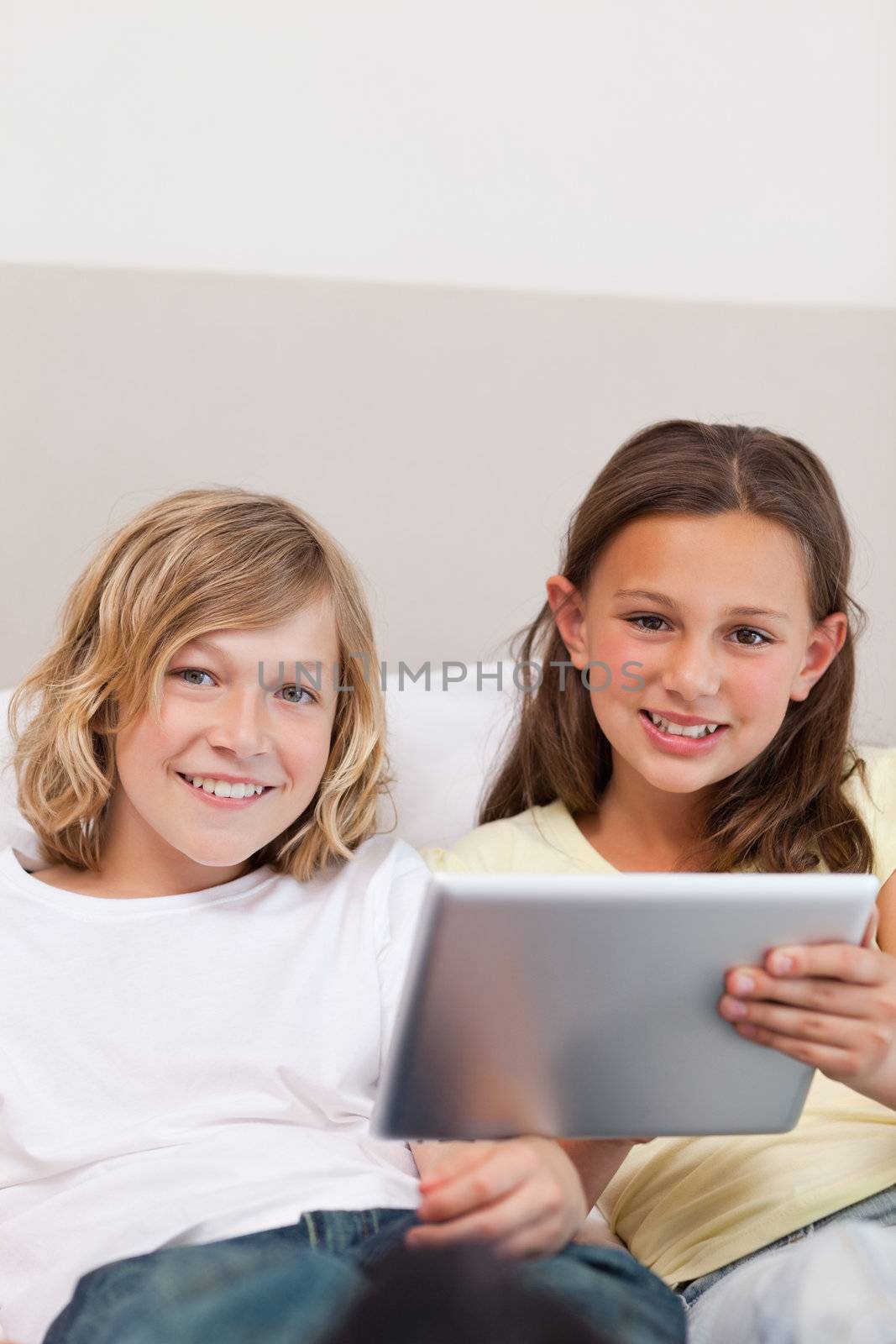 Brother and sister using tablet on the couch