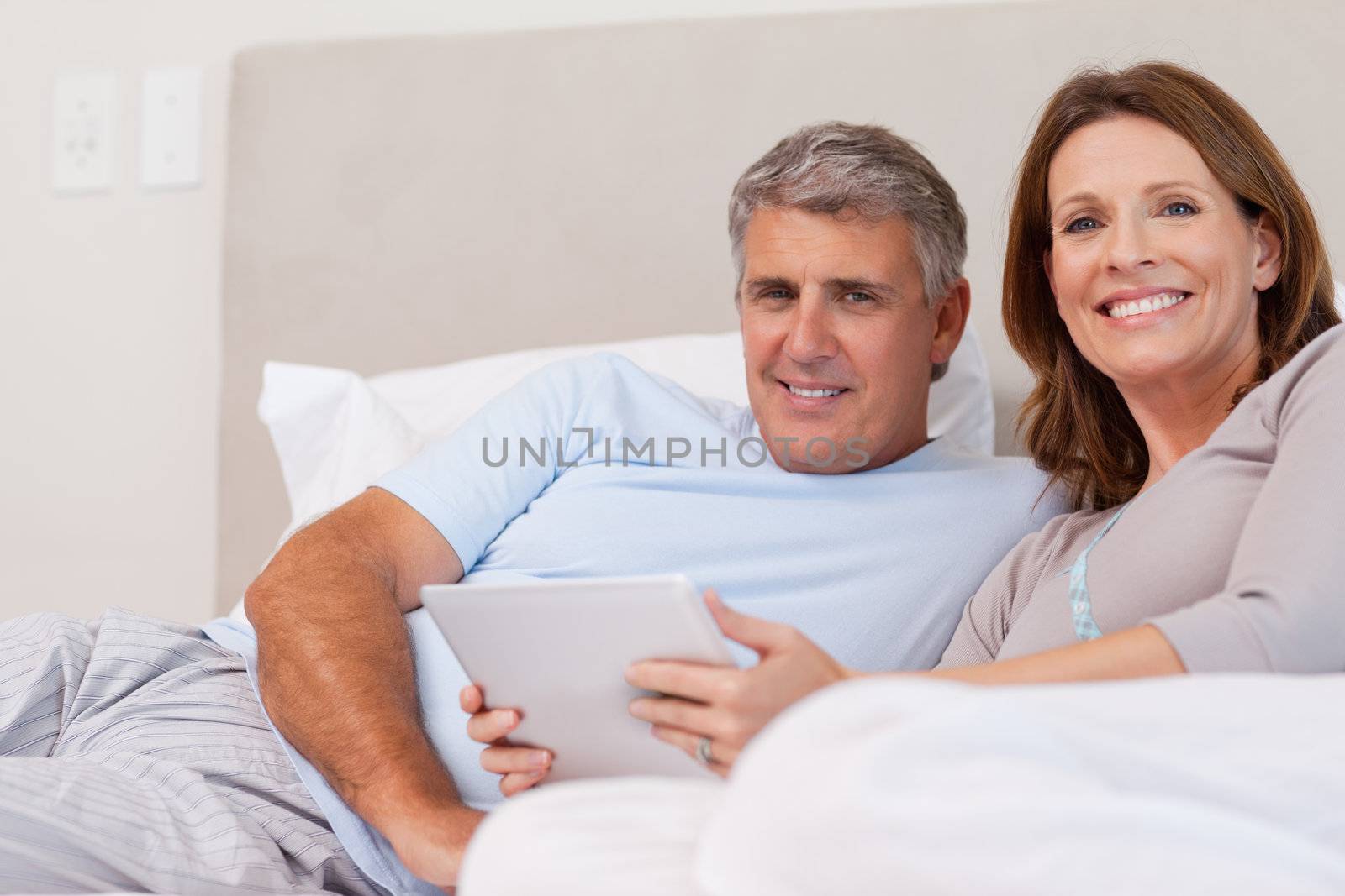 Couple with tablet in the bed