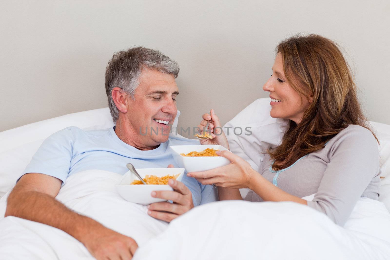 Mature couple having breakfast in their bed