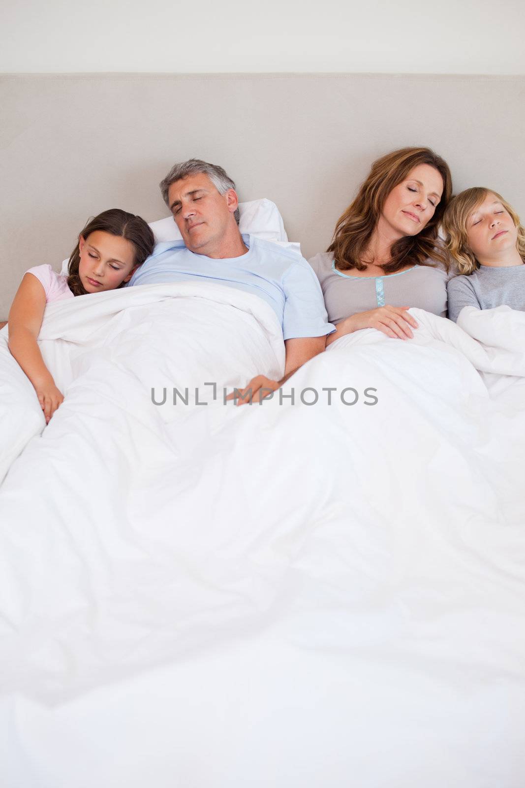 Family sleeping in the bedroom together