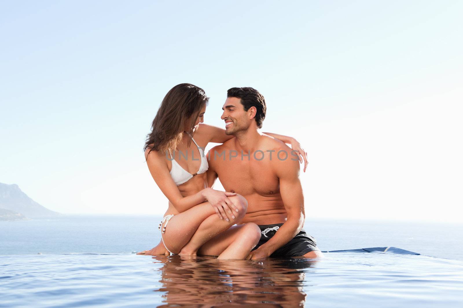 Couple sitting on the pool edge together