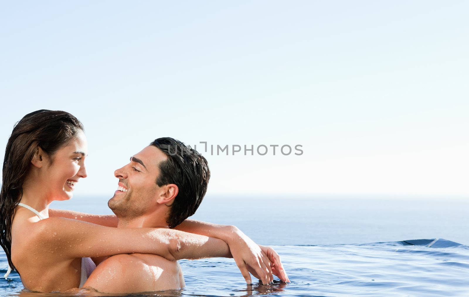 Young couple embracing in the pool
