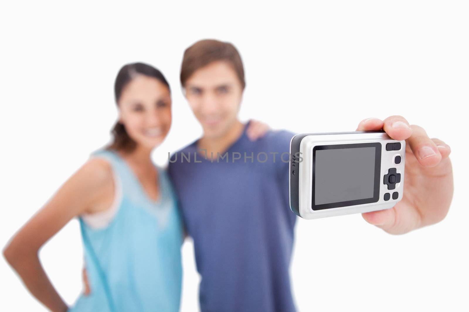 Couple taking a photo of themselves against a white background