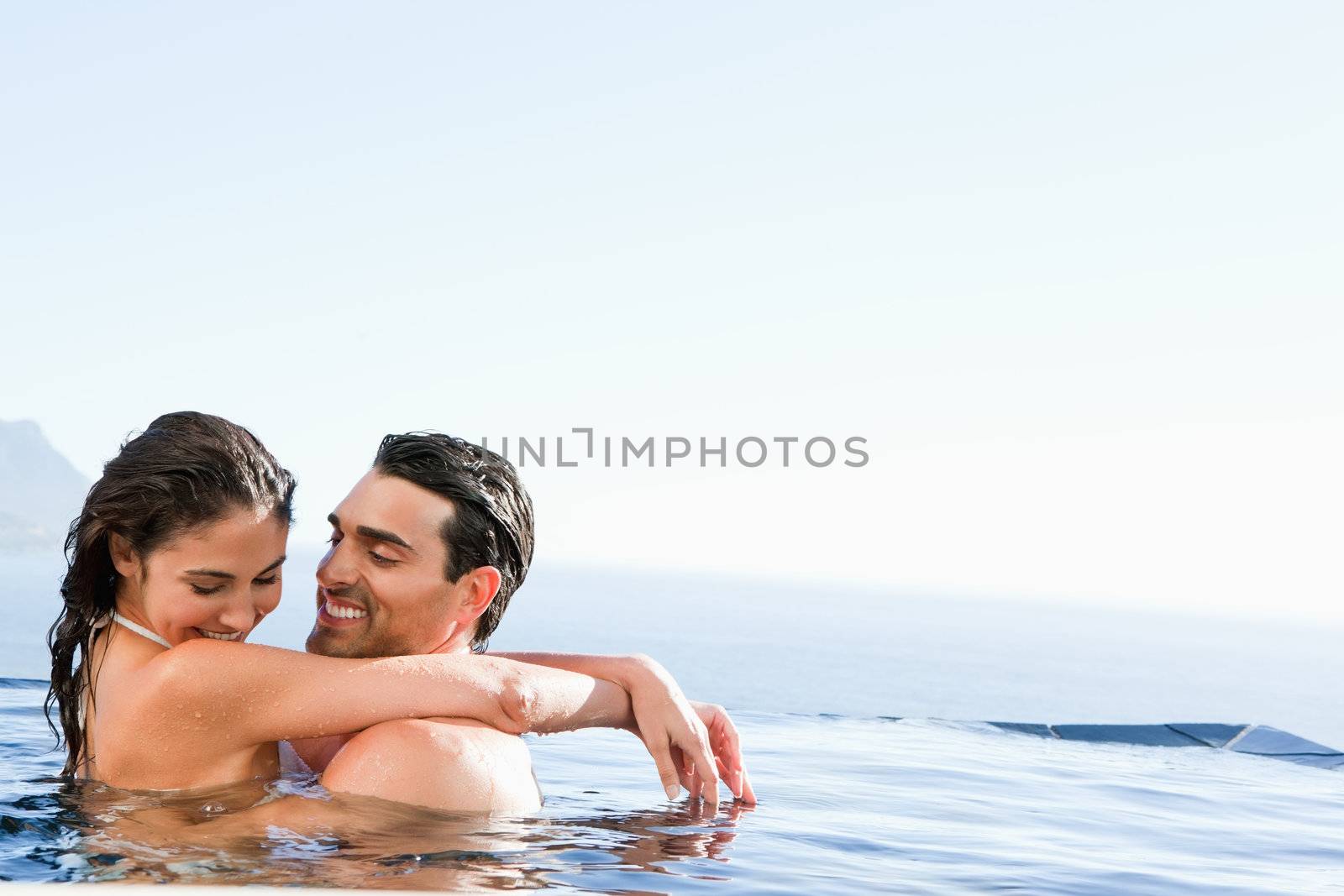 Young couple hugging in the pool